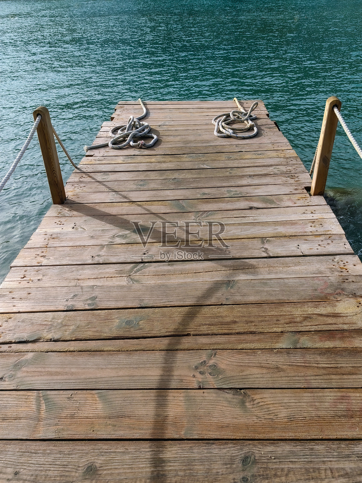 湖边木栈道的透视图。水中有一座小桥。照片摄影图片