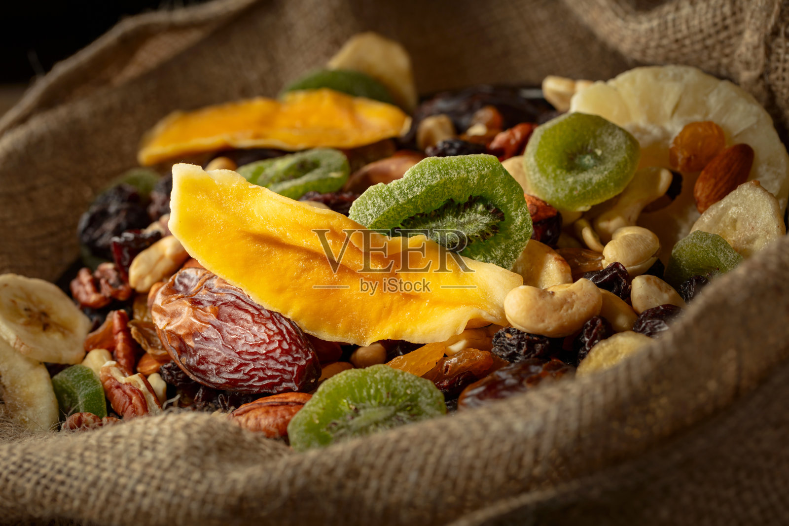 干燥的热带水果和坚果装在麻袋里。照片摄影图片