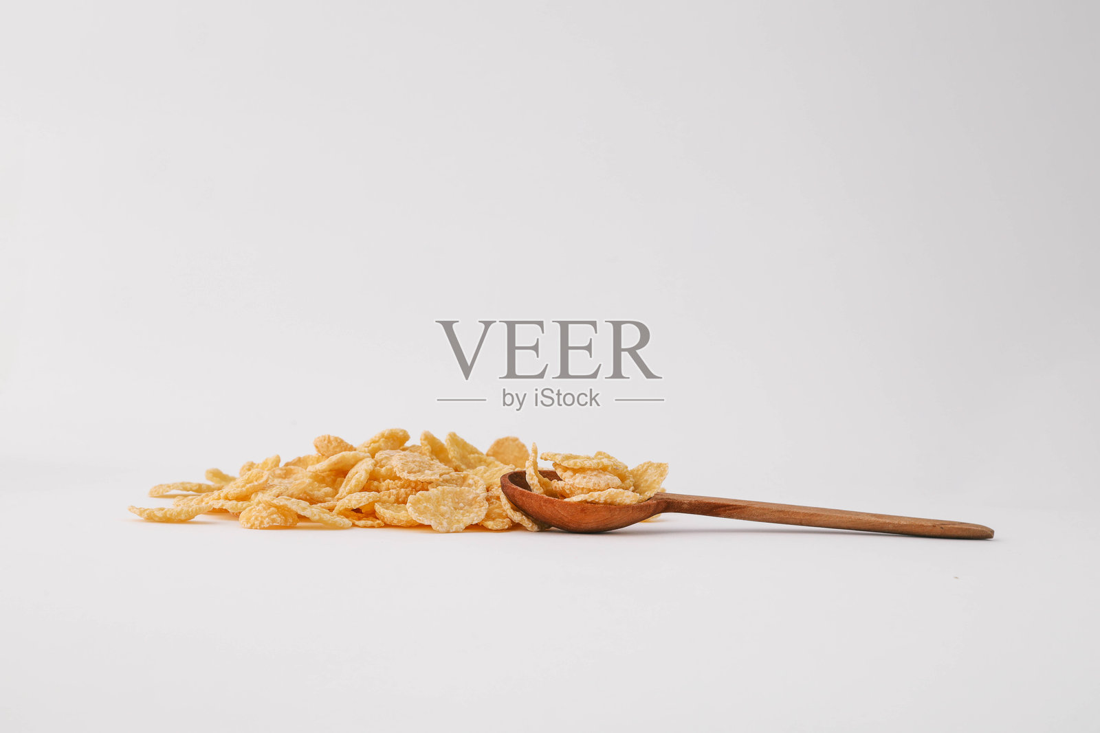 金色玉米片与木勺在白色背景上。完美展现健康早餐或零食的创意,突出质感和自然魅力。照片摄影图片