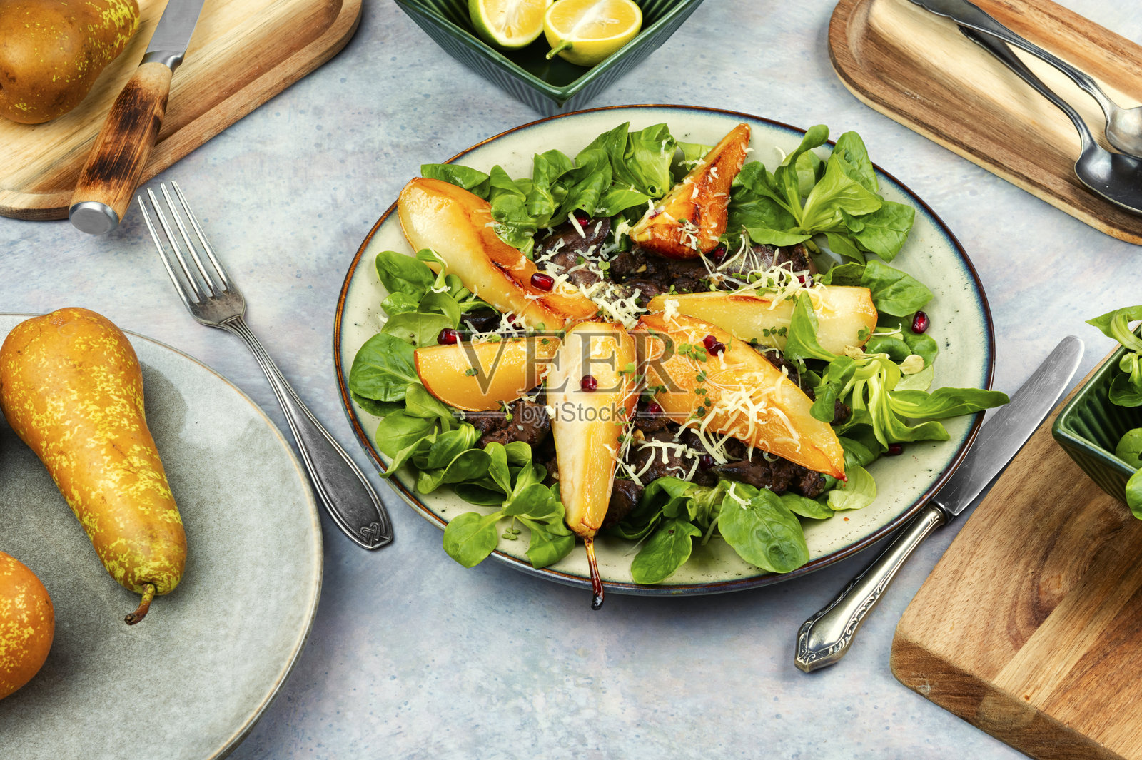 盘子里的肝脏沙拉和焦糖梨。照片摄影图片