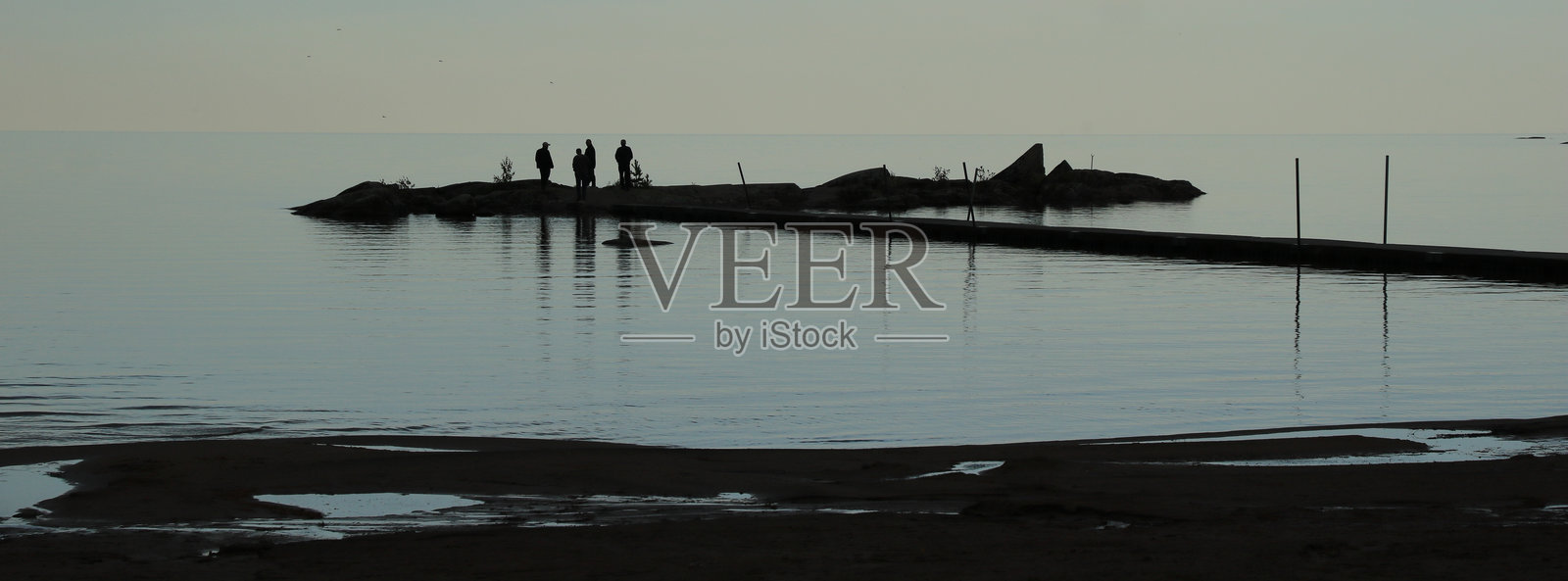 瑞典梅勒鲁德维塔桑达尔湖岸边的人影和岩石 formations。照片摄影图片