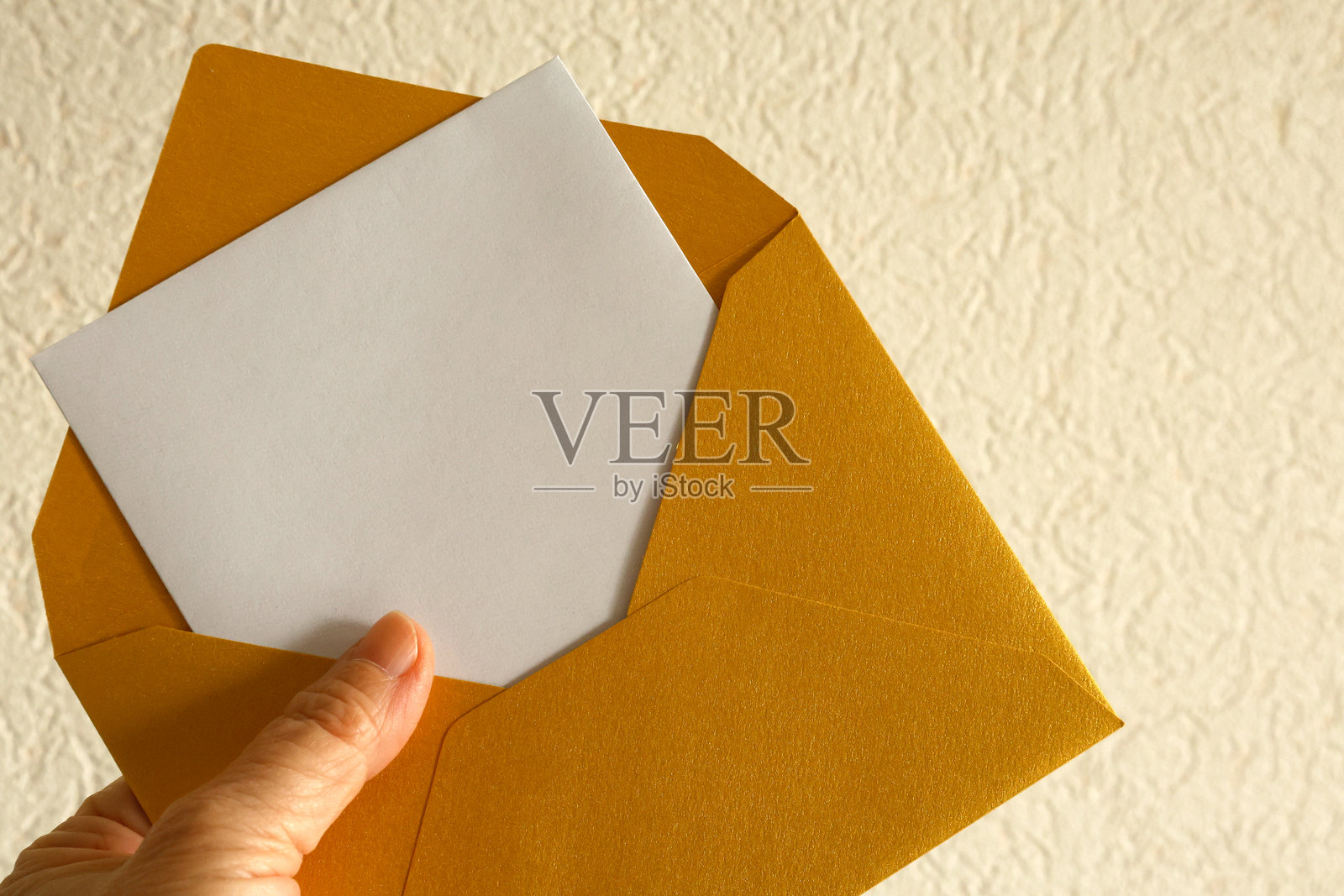 手握金色信封照片摄影图片