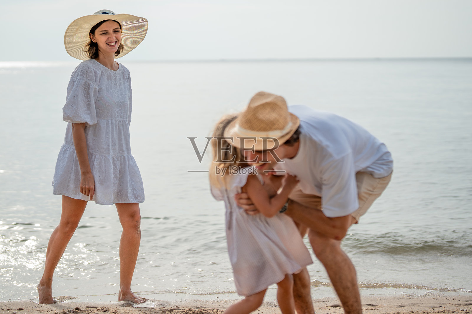 快乐的家庭假期在海滩上。照片摄影图片