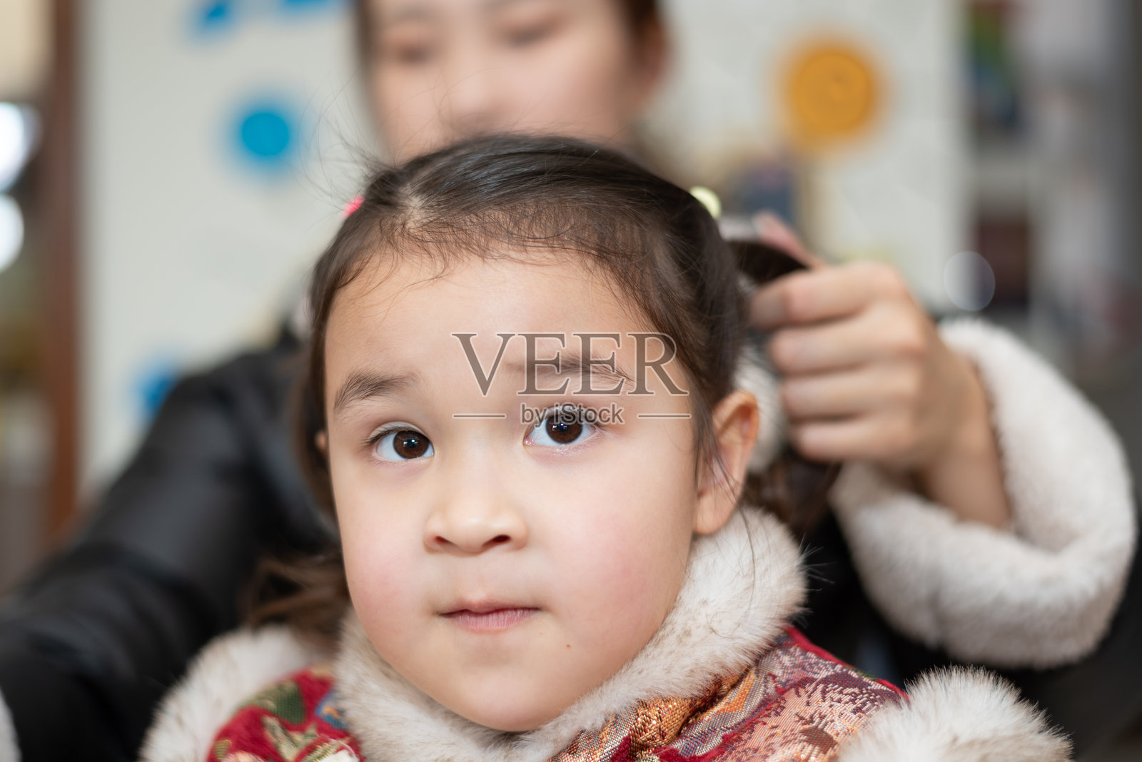 年轻的亚洲母亲为女儿扎头发照片摄影图片