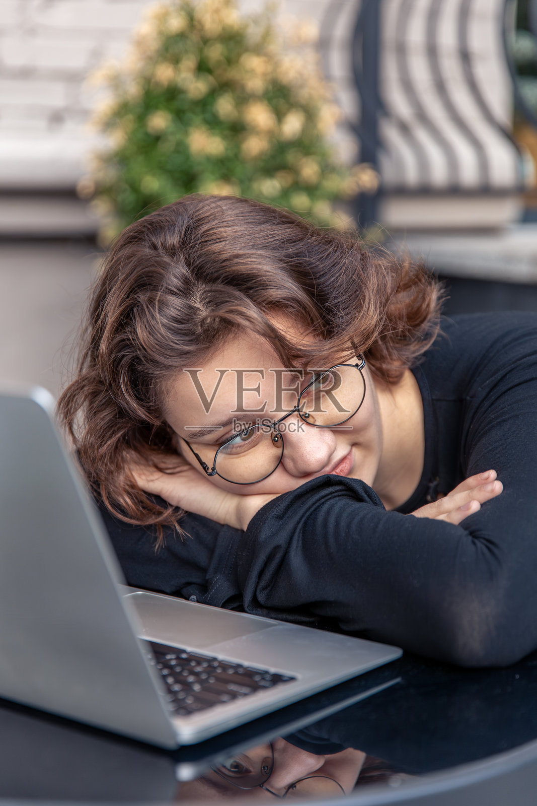 伤心疲惫的年轻女性在使用笔记本电脑。情感概念。照片摄影图片