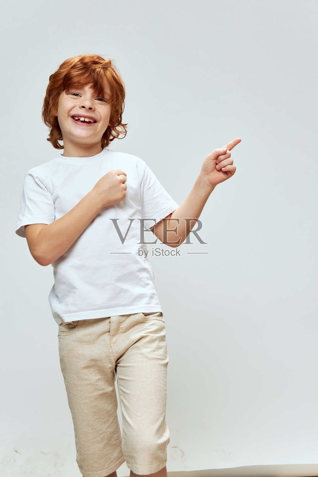 红发男孩微笑着竖起大拇指,旁边留有空白空间照片摄影图片