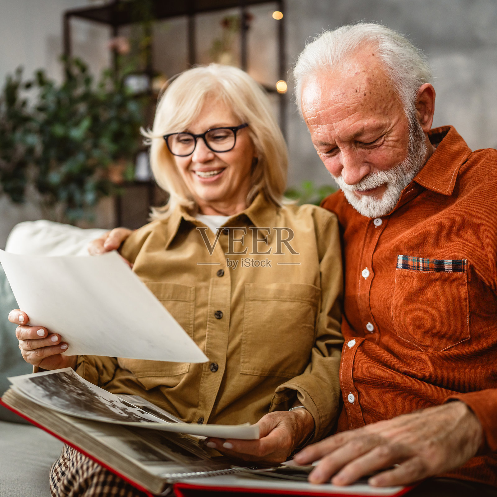 老年夫妇坐在沙发上翻看家庭照片册照片摄影图片