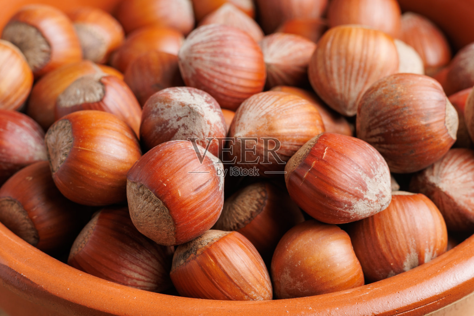 一组装在陶土容器中的榛子,准备食用照片摄影图片