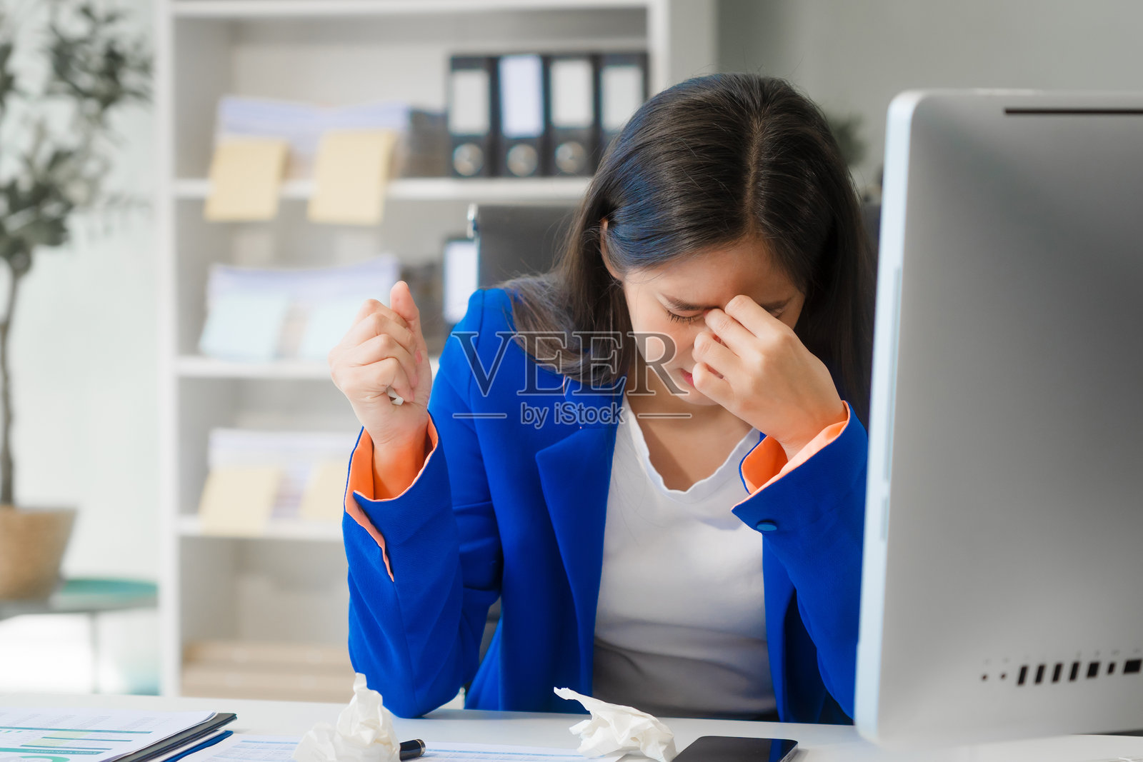 亚洲女商人在现代办公室的桌子上工作,努力克服办公室综合症。照片摄影图片