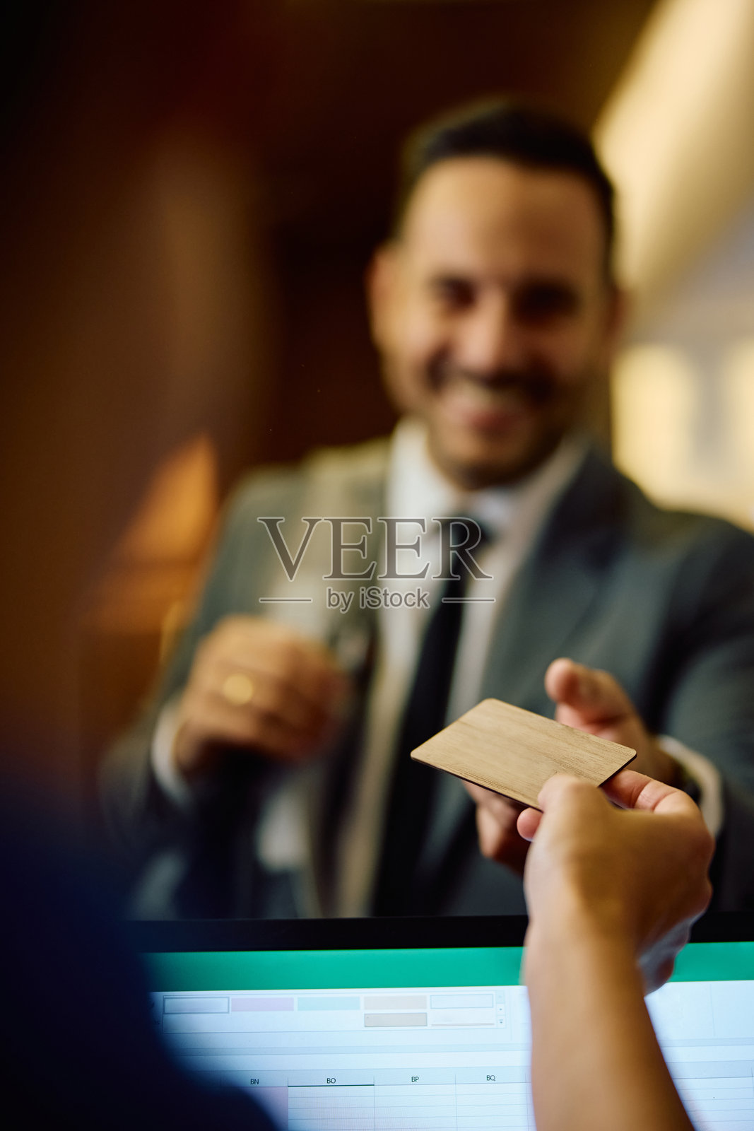 健身房接待员将会员卡递给商人的特写镜头。照片摄影图片