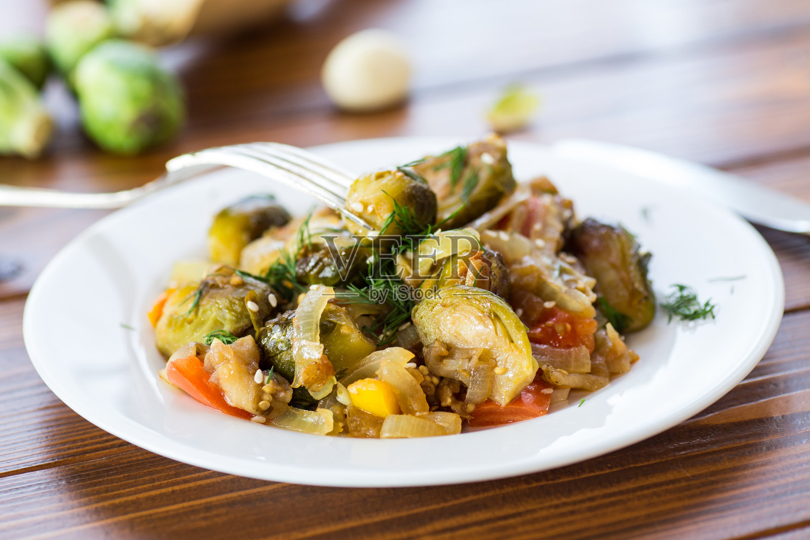 用蔬菜和香料烹饪的球芽甘蓝,摆放在木桌上照片摄影图片