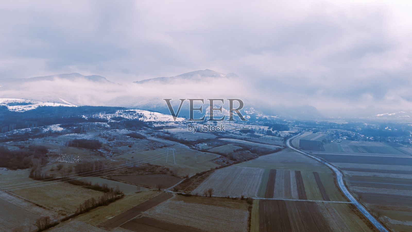 云层下的田野和山脉的鸟瞰图照片摄影图片