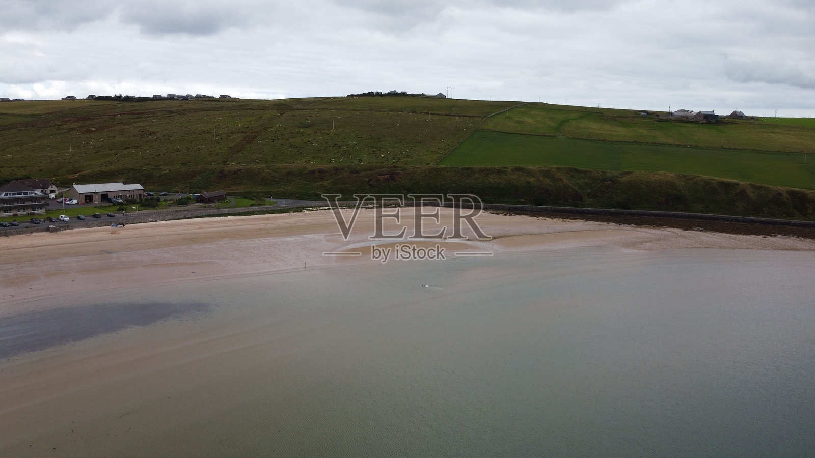 沙滩与沙质海岸和绿色山丘照片摄影图片