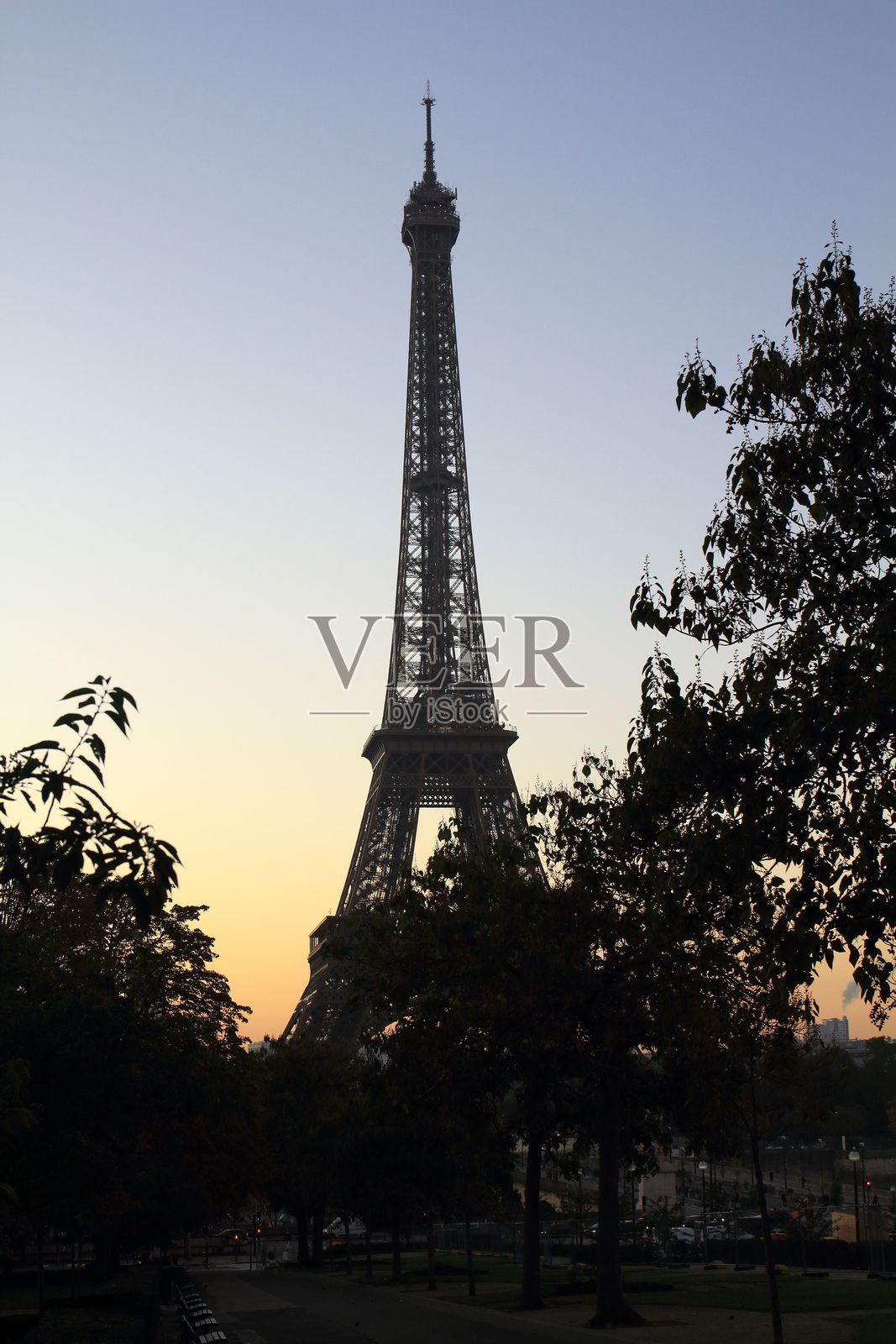 日落时分的埃菲尔铁塔与剪影树木照片摄影图片
