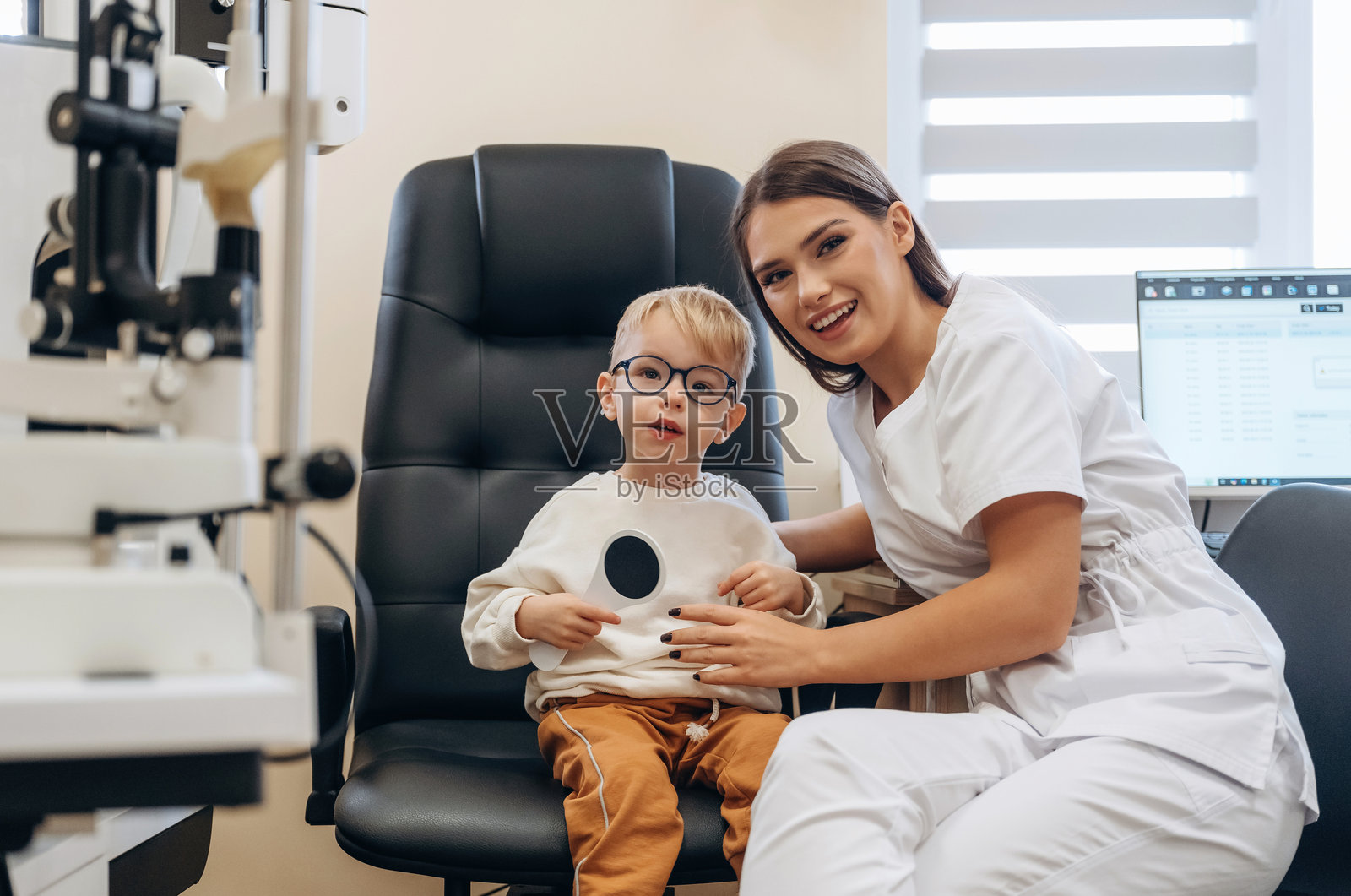 戴着眼镜的小男孩在眼科诊所进行检查照片摄影图片