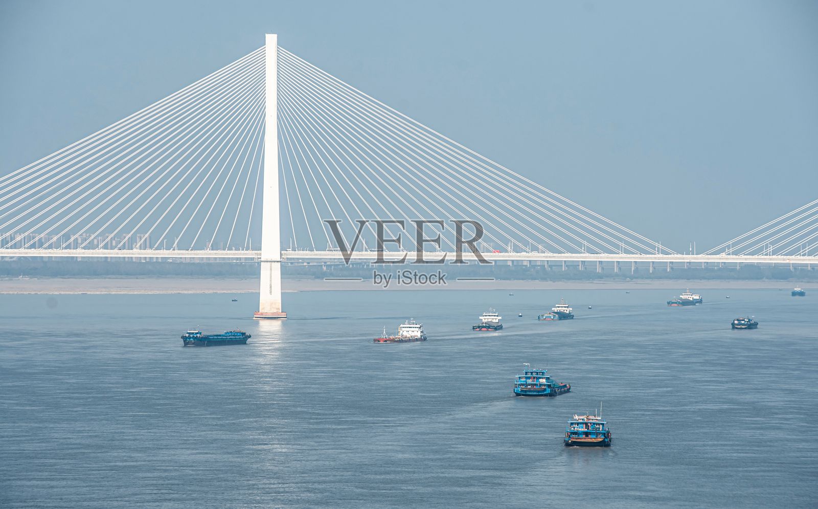 跨河的斜拉桥与船只。照片摄影图片