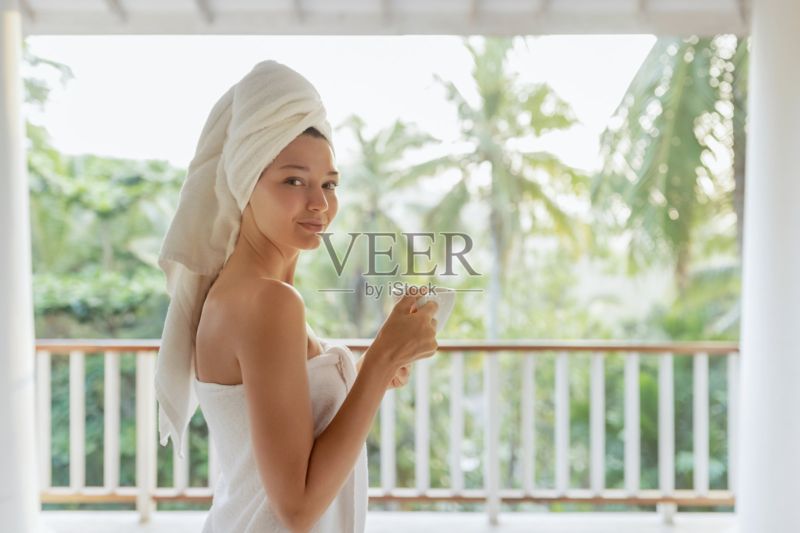 女人在阳台上享受早晨咖啡照片摄影图片