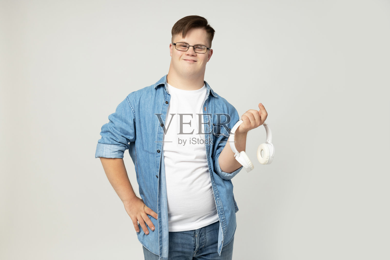 一位手持耳机的年轻唐氏综合症男性照片摄影图片