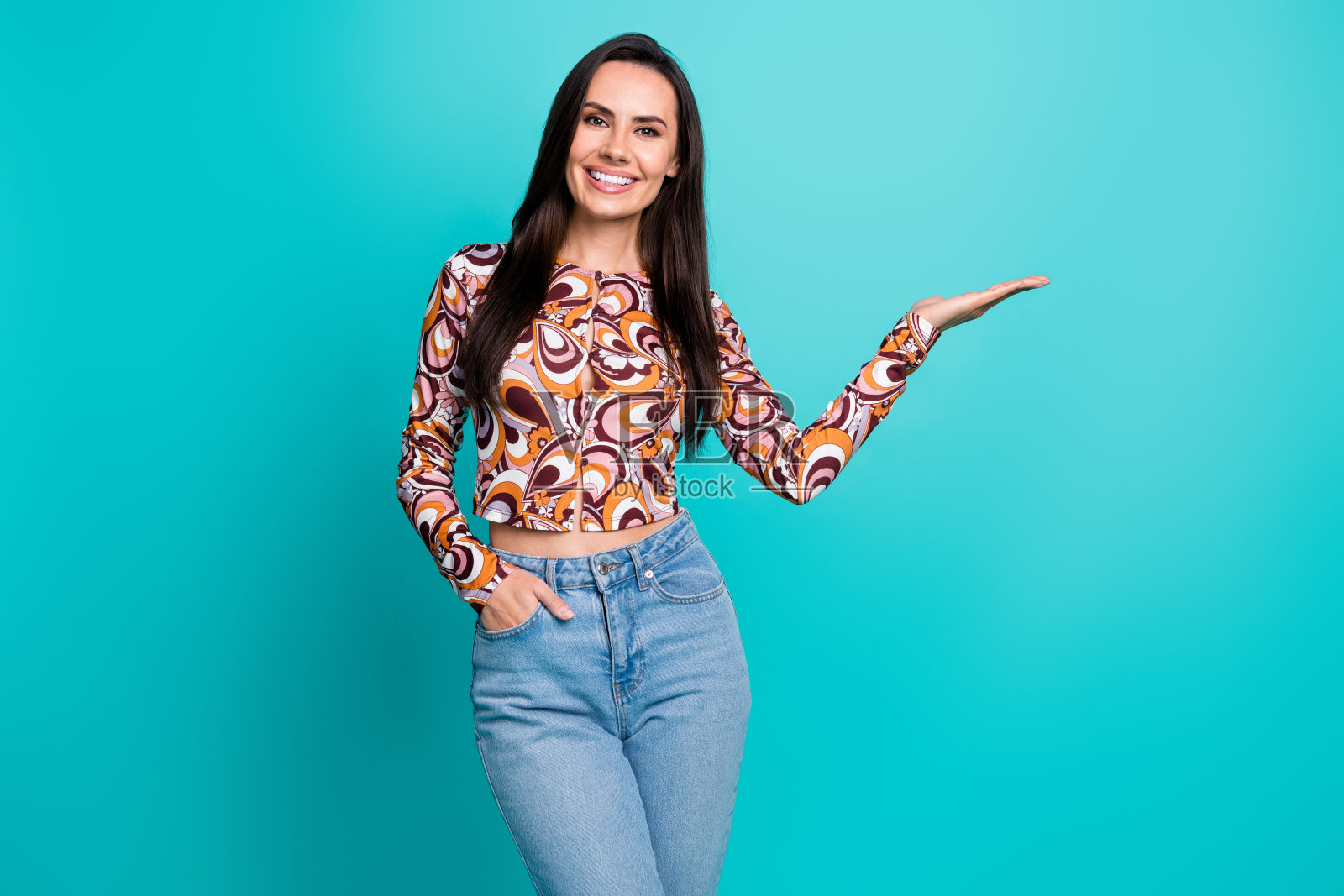 可爱的女孩穿着印花衬衫,手臂伸向空旷的空间,背景为青绿色。照片摄影图片