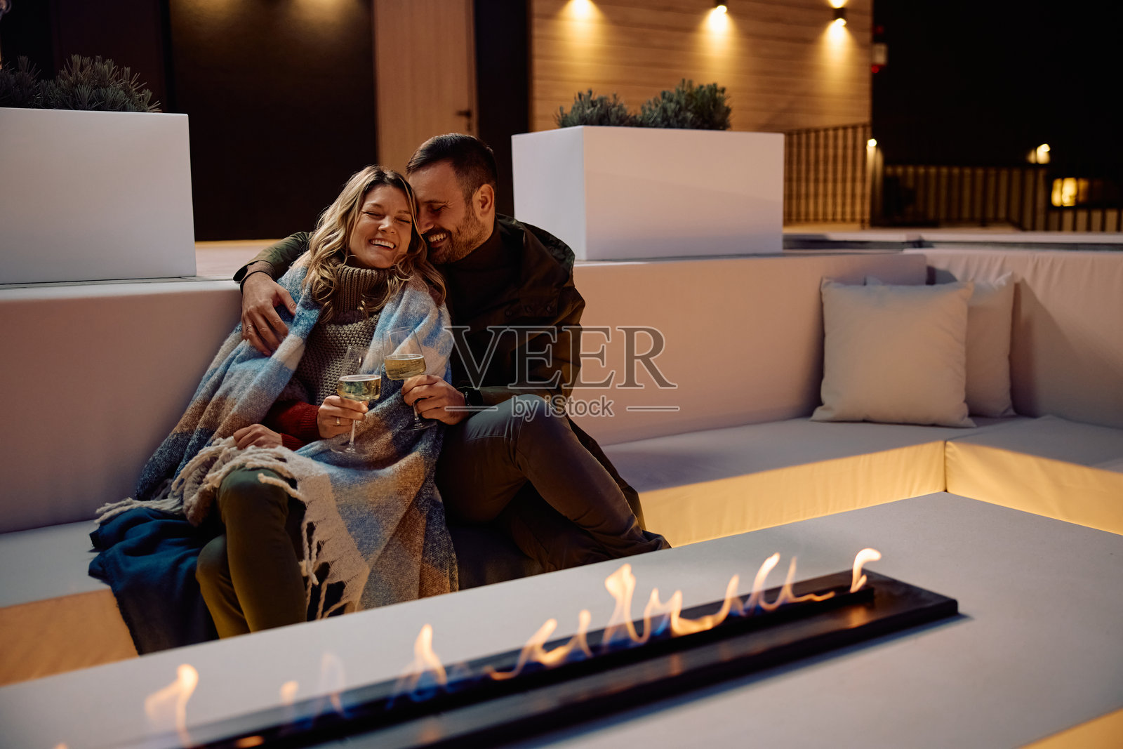 一对恩爱情侣在露台上享受彼此的爱与一杯美酒。照片摄影图片