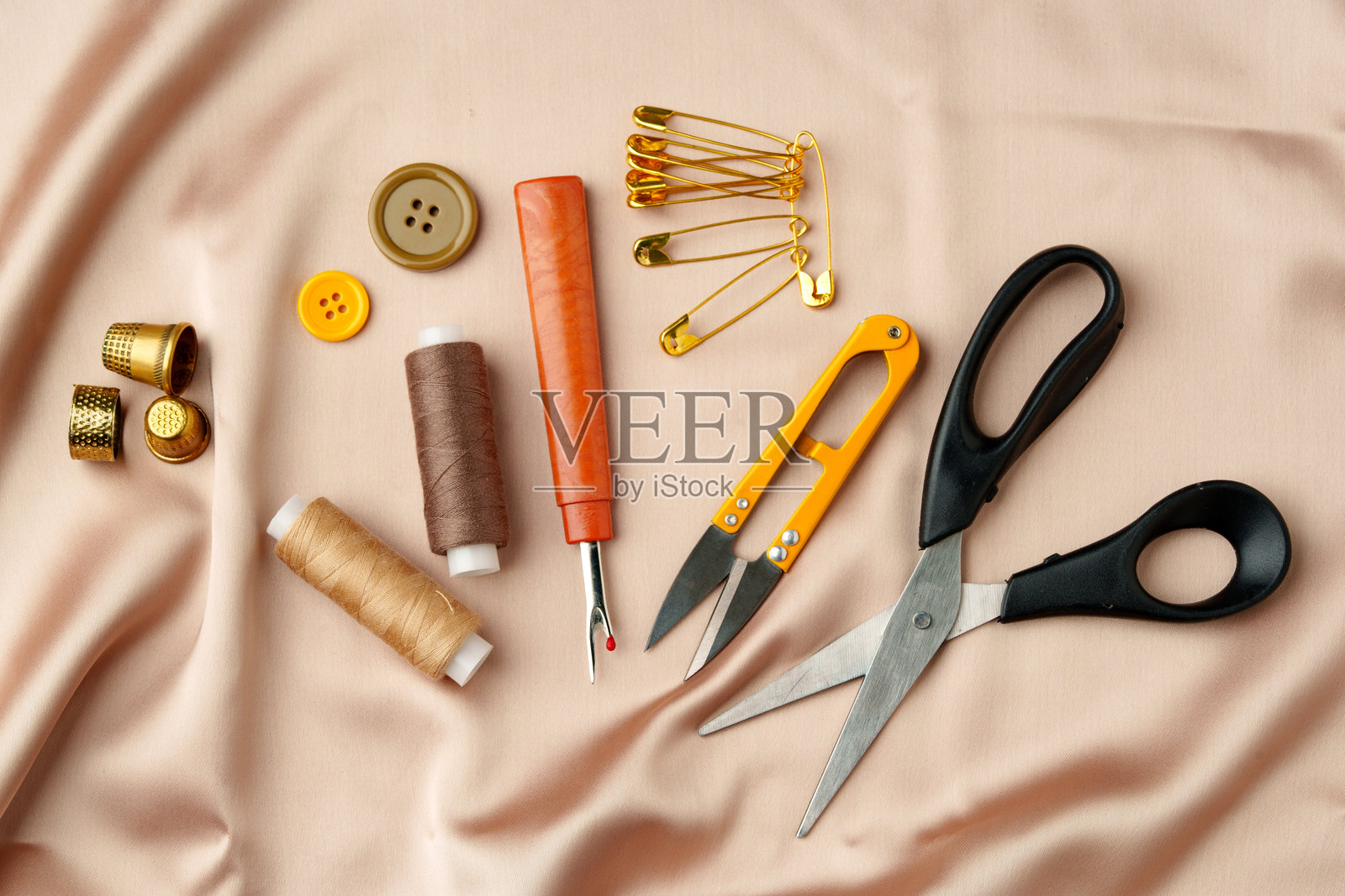 缝纫工具和材料整齐地摆放在柔软的布料上,展示了创意项目所需的基本手工艺用品。照片摄影图片