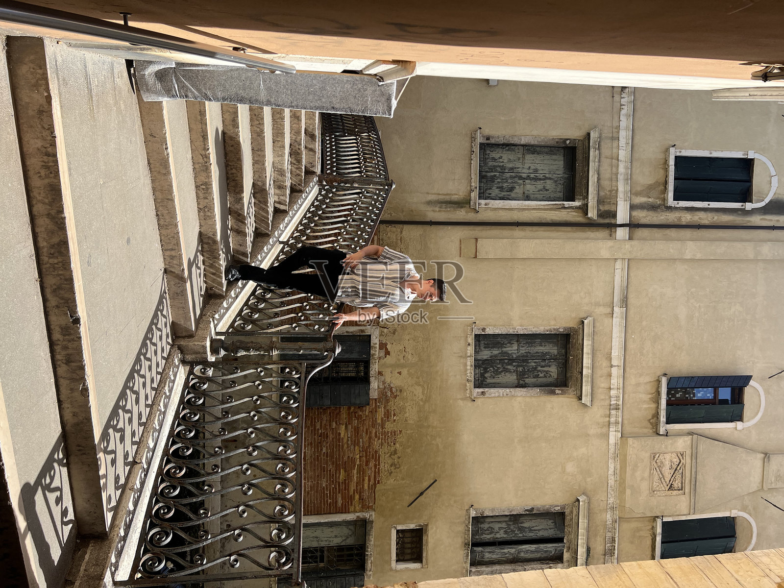 威尼斯建筑旁站着的男人的低角度视图照片摄影图片