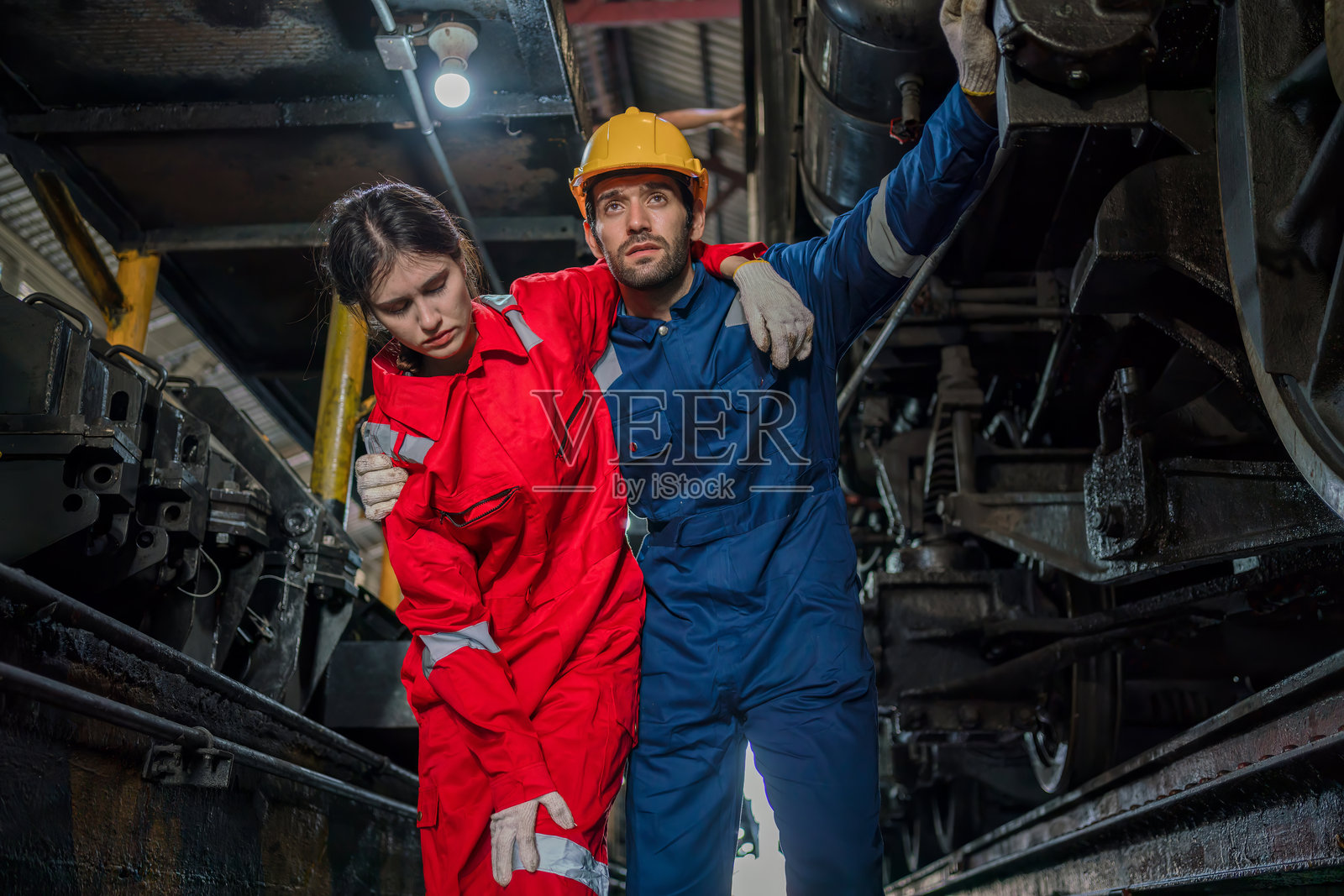 工厂工人工作事故的急救支持。男性工人在仓库地面发生事故。照片摄影图片