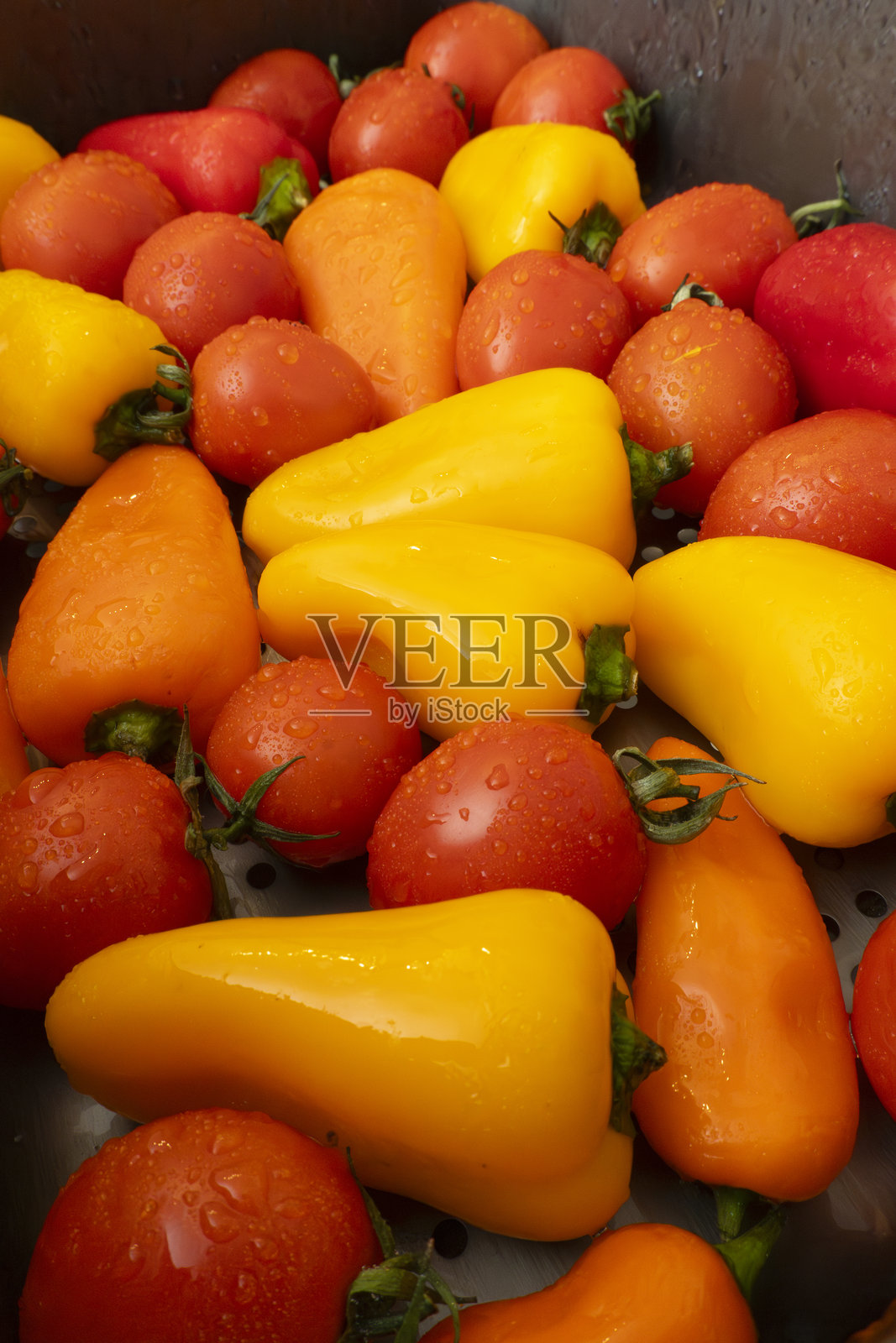 市场展示中五彩缤纷的新鲜辣椒和番茄排列。照片摄影图片