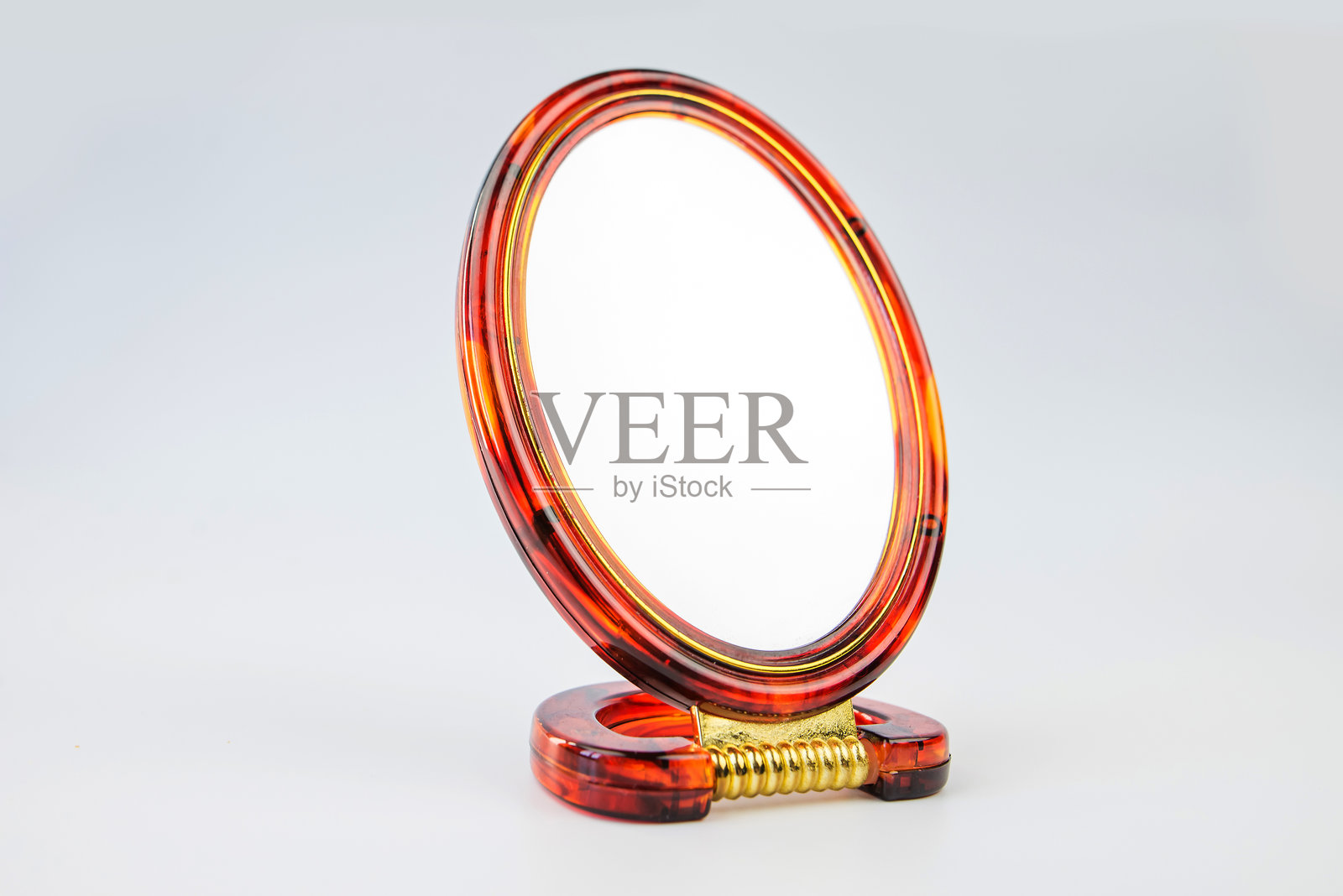 带棕色框的镜子,孤立在白色背景上。小桌面镜子。照片摄影图片