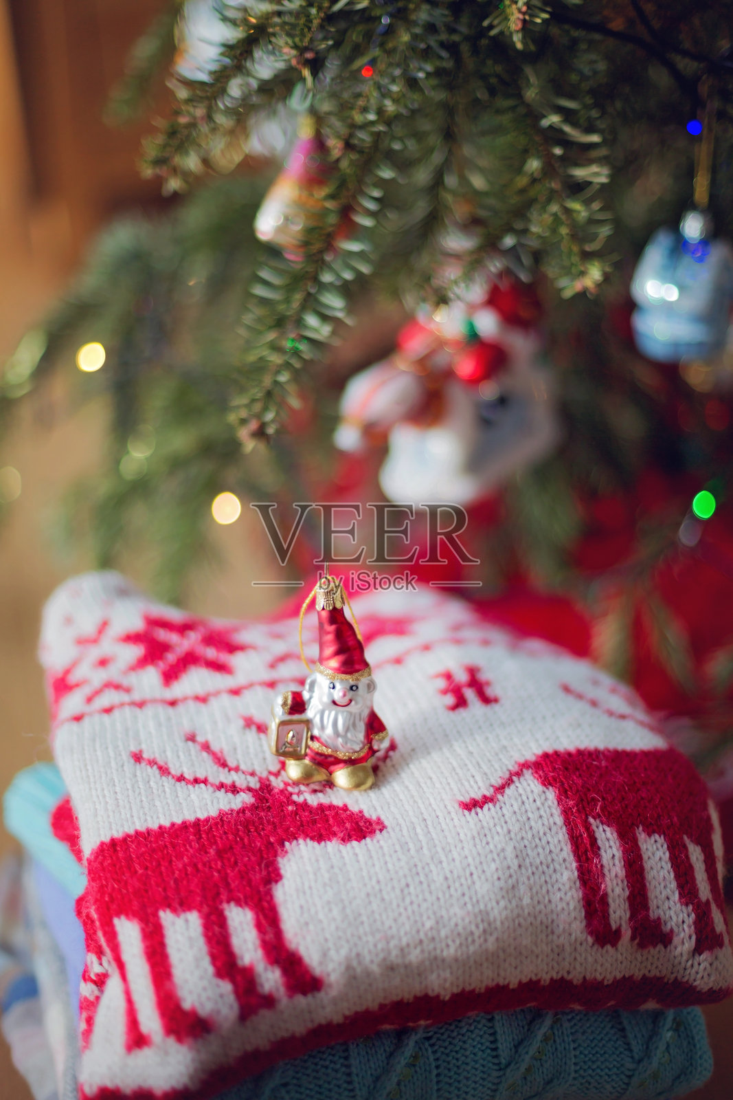 圣诞树前一堆毛衣上的圣诞装饰品照片摄影图片