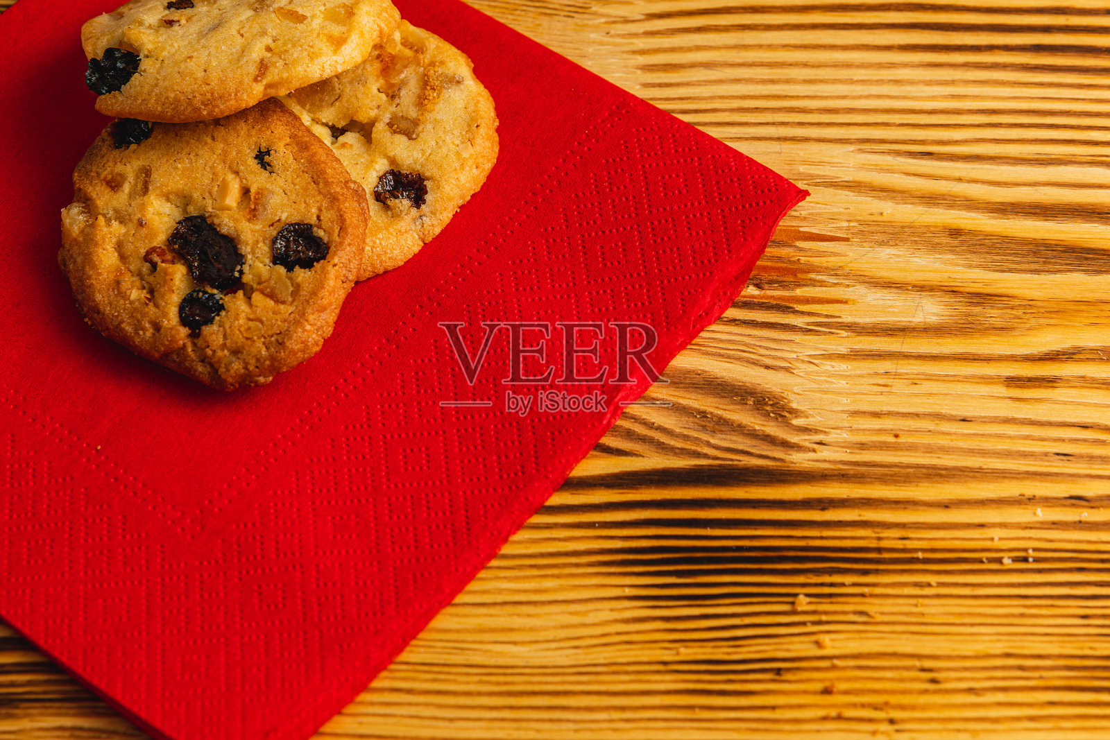 美味的葡萄干饼干放在红色餐巾上,圣诞节概念照片摄影图片