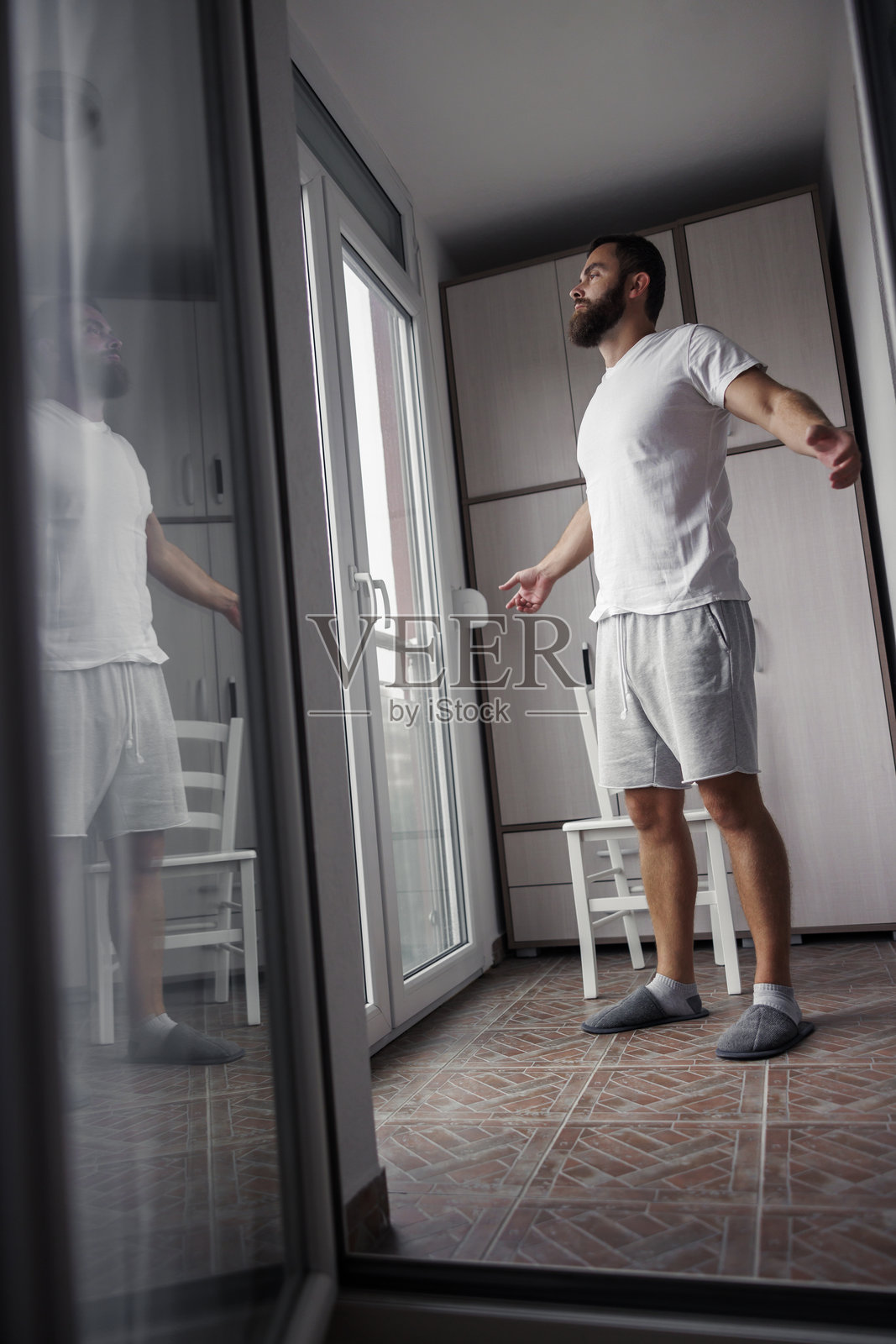 男子在家晨练时伸展身体照片摄影图片