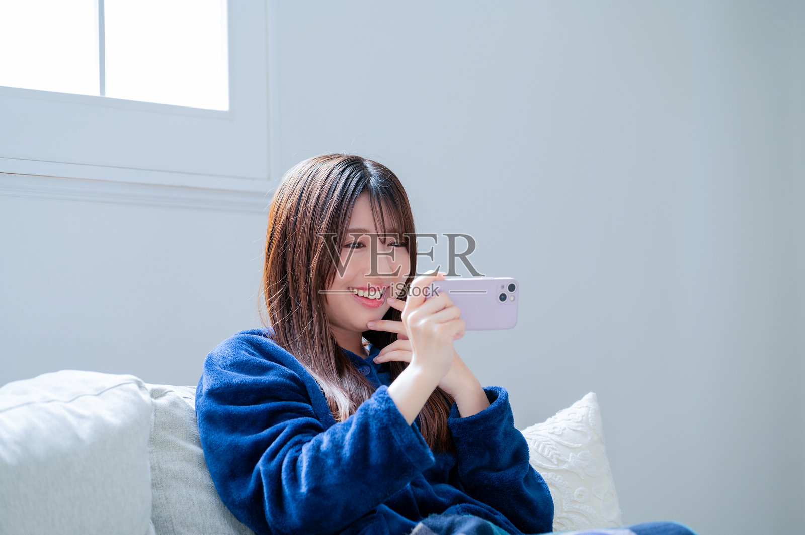 一位日本女性在客厅里看着她的智能手机照片摄影图片