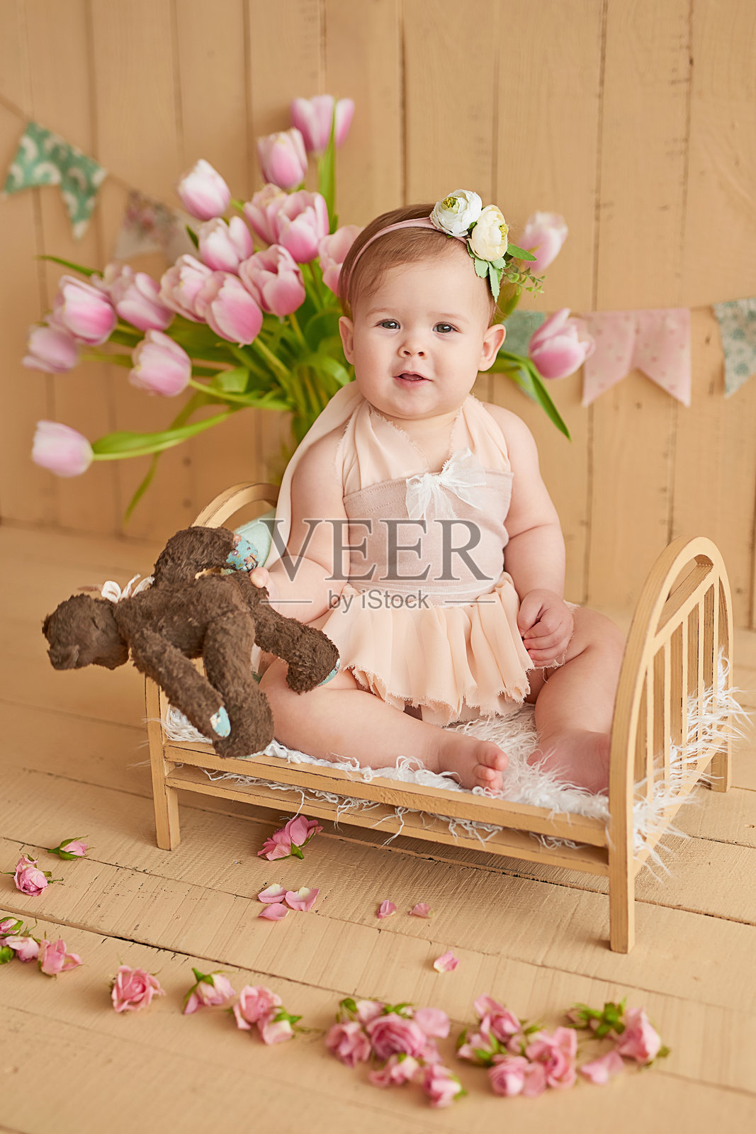 可爱的搞笑宝宝与花朵。母亲节的复活节贺卡。可爱的小女孩与花朵。儿童节。照片摄影图片