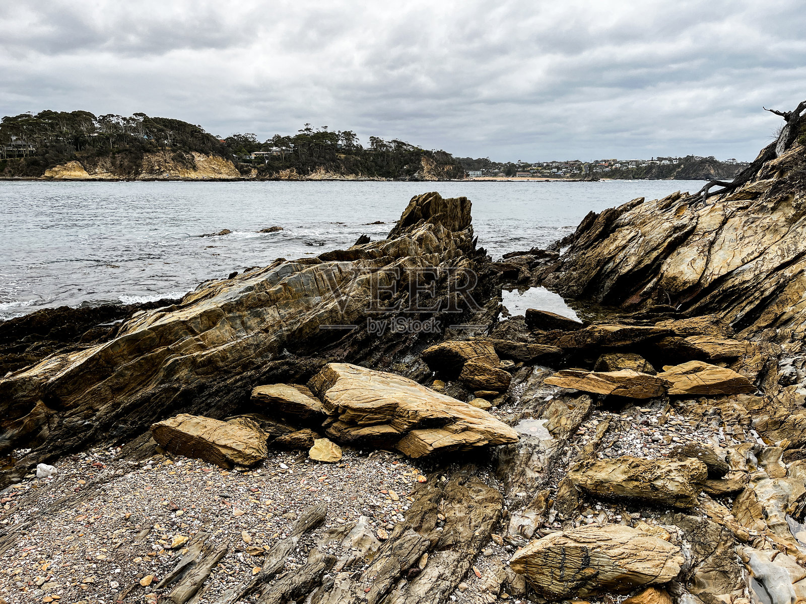 岩石海岸线突显了砂岩悬崖,夹杂着页岩侵入和璀璨的石英缝隙,展示了复杂的自然图案。照片摄影图片