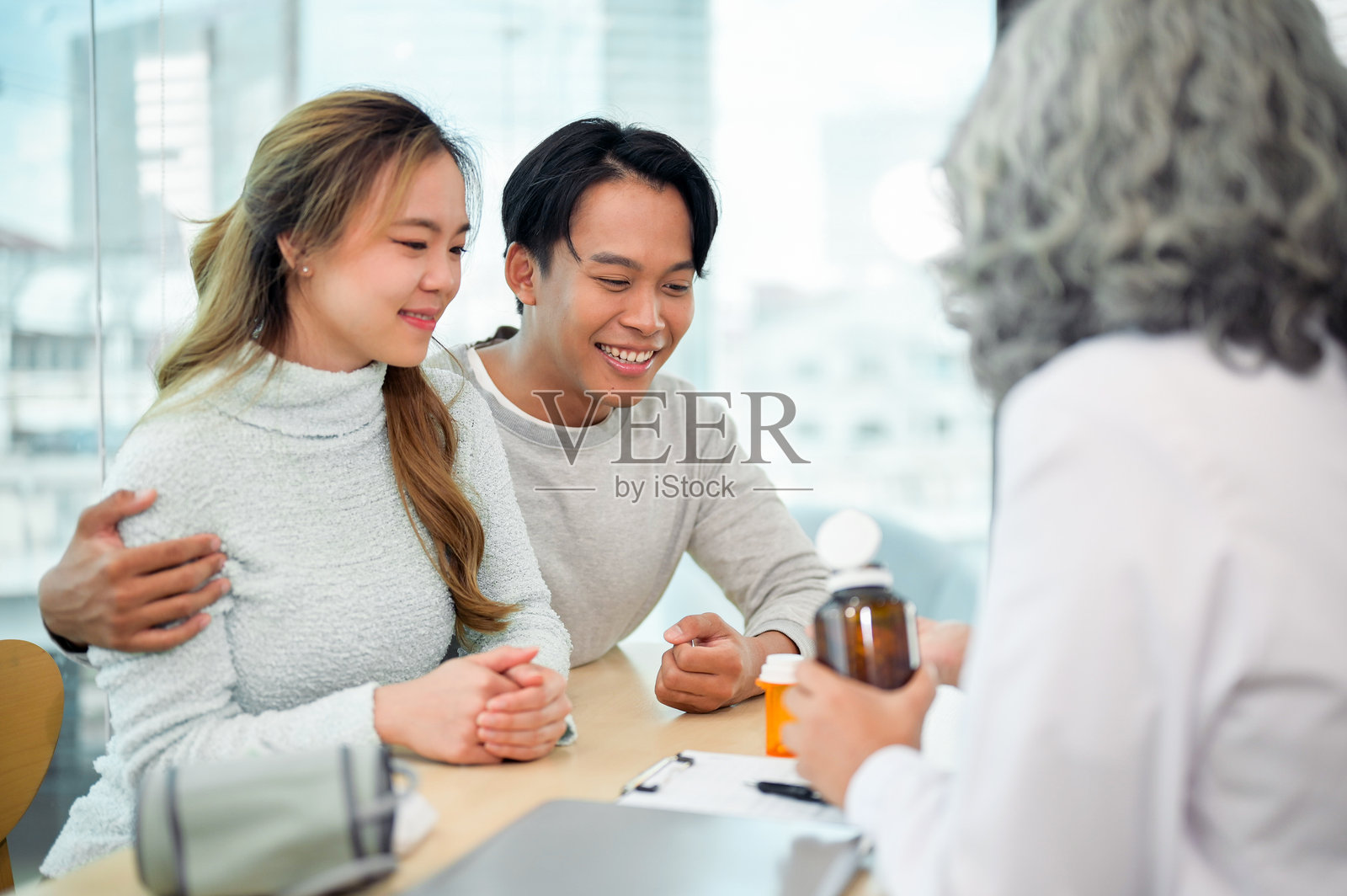 一对可爱的年轻亚洲夫妇一起去看医生,讨论家庭计划和怀孕。照片摄影图片