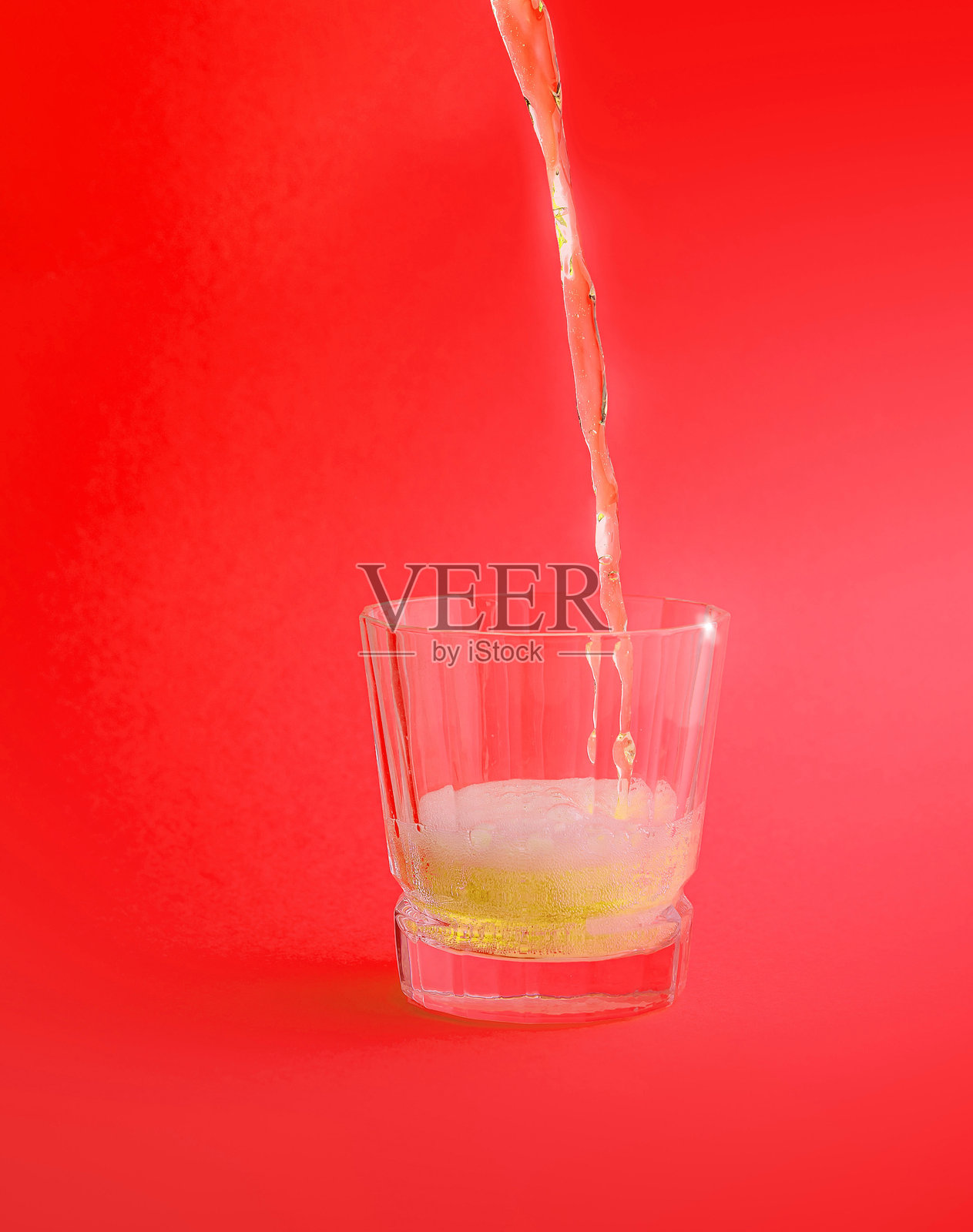 啤酒在红色背景下倒入玻璃杯中照片摄影图片