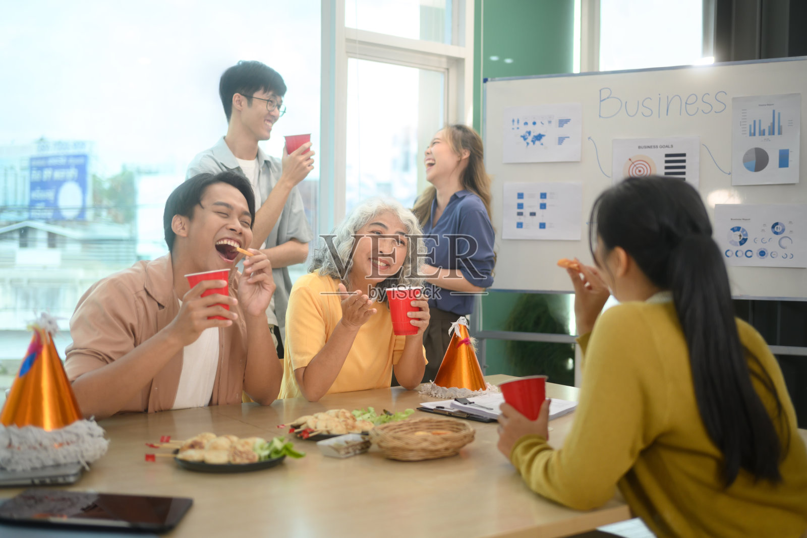 一群商务同事在办公室聚会上享受饮品和交谈照片摄影图片