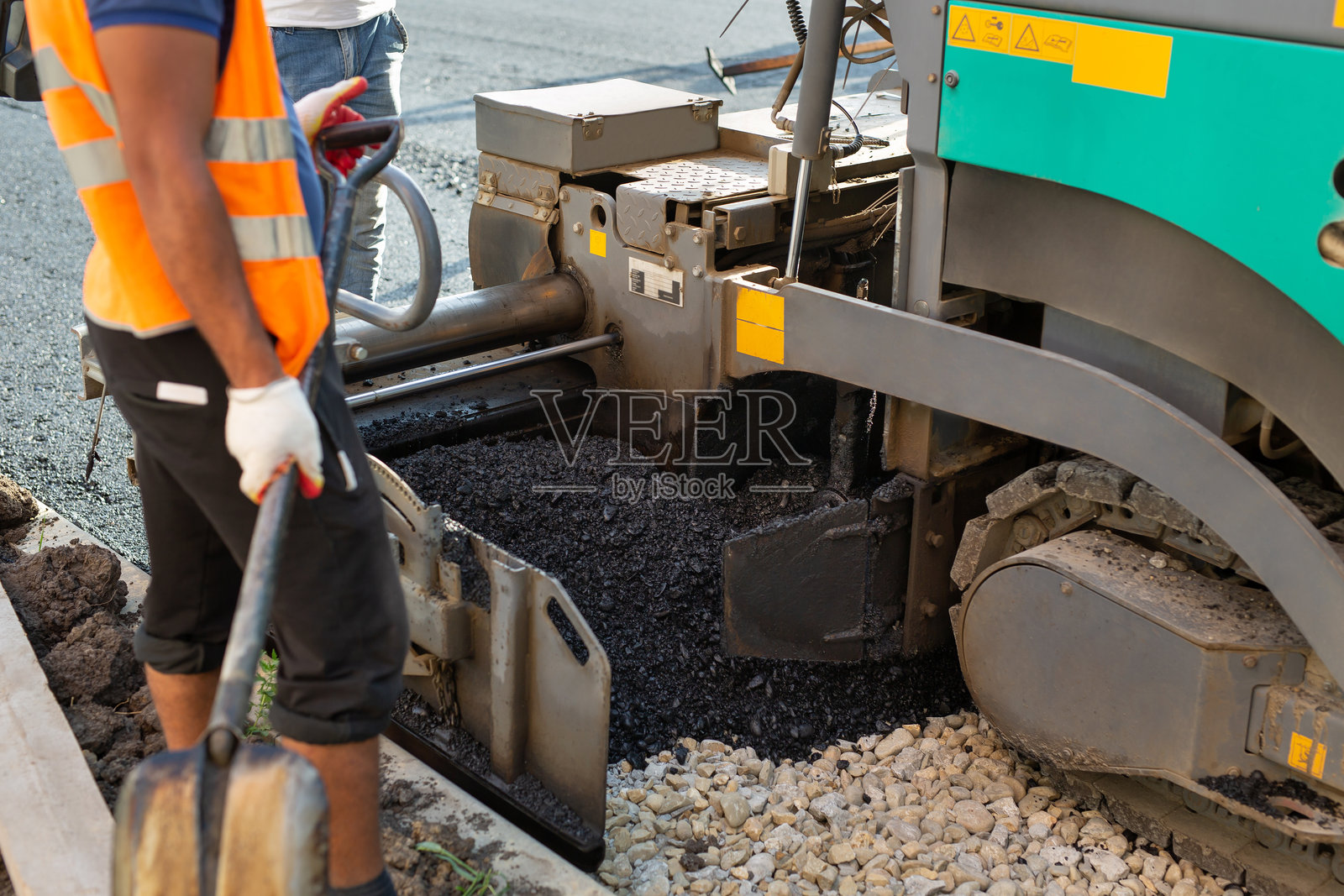 公路施工现场的沥青摊铺机或沥青铺路机。道路修复。照片摄影图片