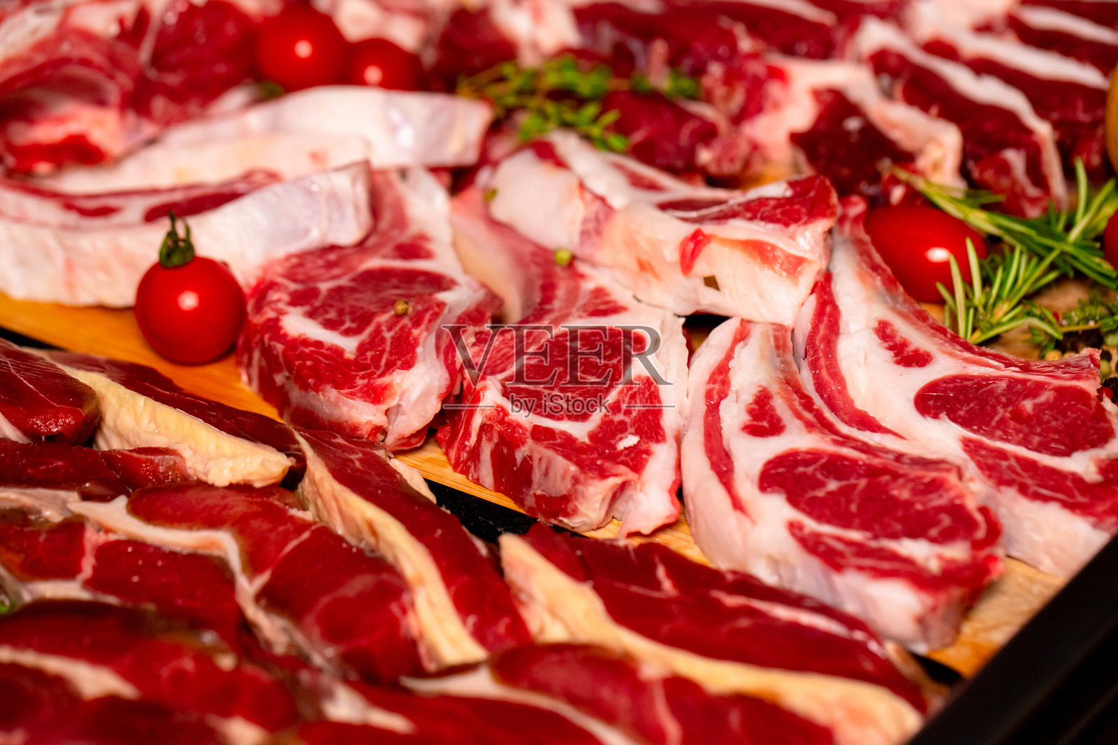 特写羊肋排 steak,周围是各种手工肉制品。照片摄影图片