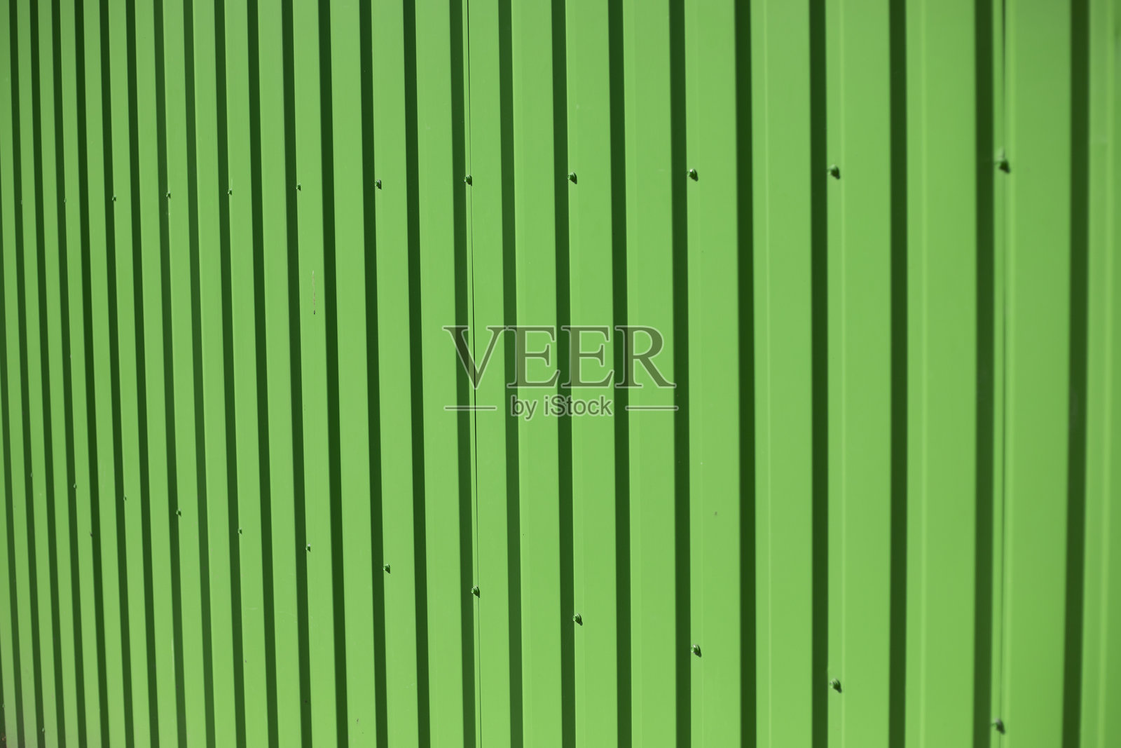 绿色墙壁。钢材型材。波纹表面。照片摄影图片