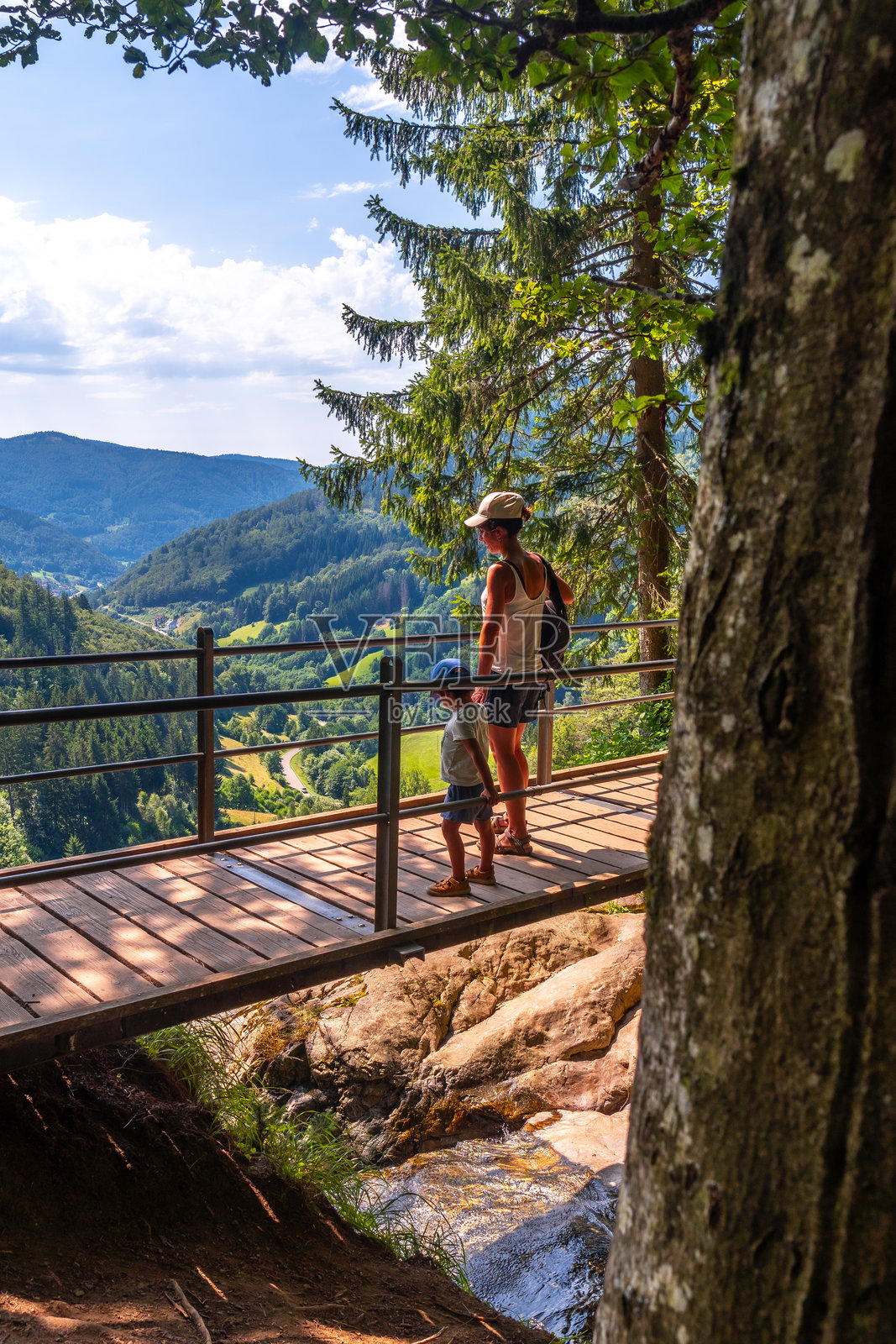德国黑森林的托特瑙瀑布上,母亲与儿子在桥上。照片摄影图片
