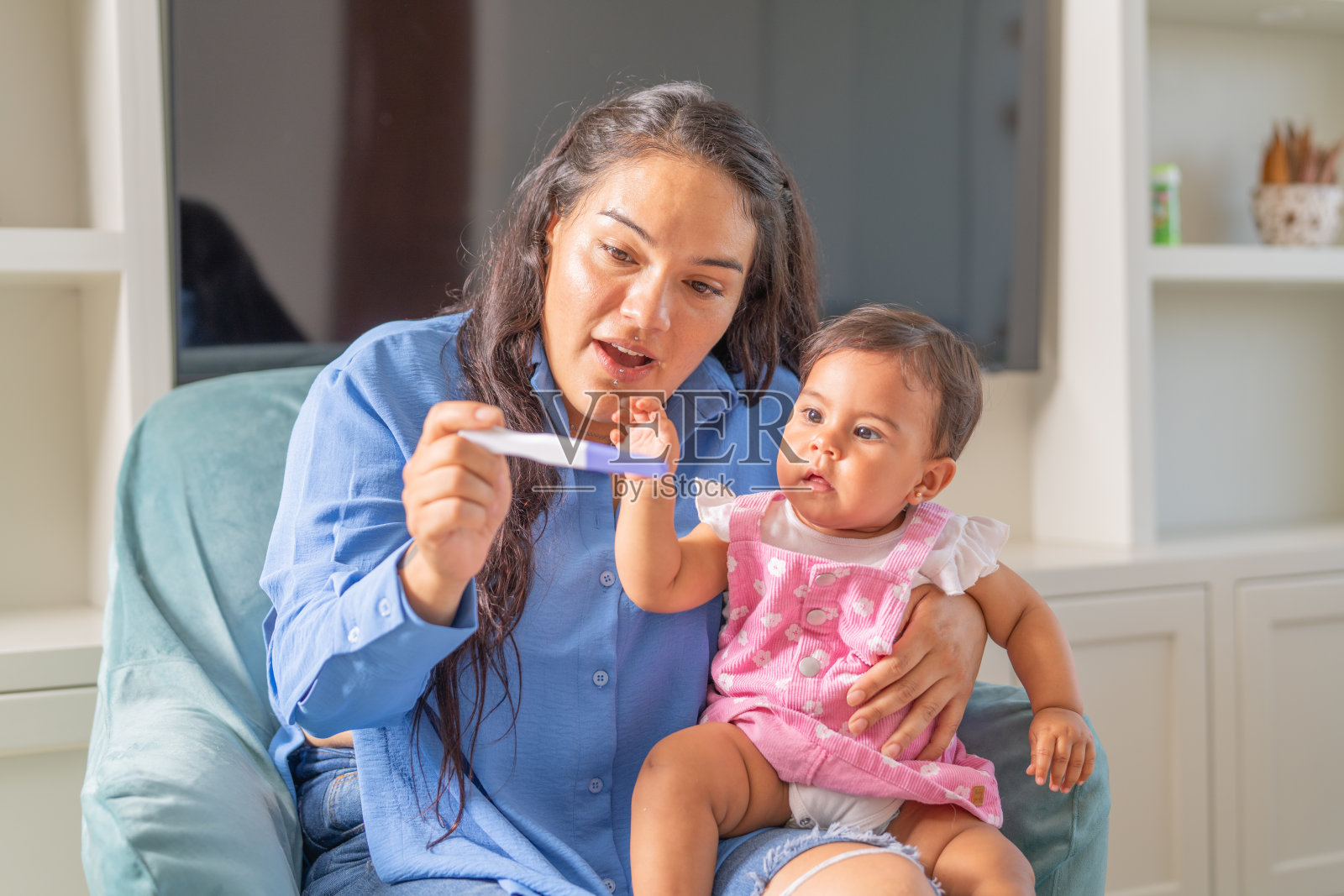 母亲向女儿展示怀孕测试棒照片摄影图片