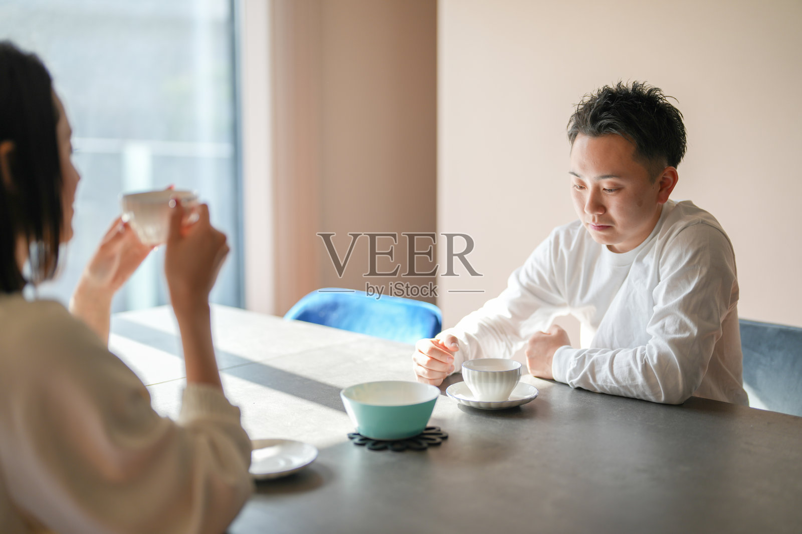 一对日本夫妇,30多岁的女性和20多岁的男性,在家享受下午茶时光。照片摄影图片