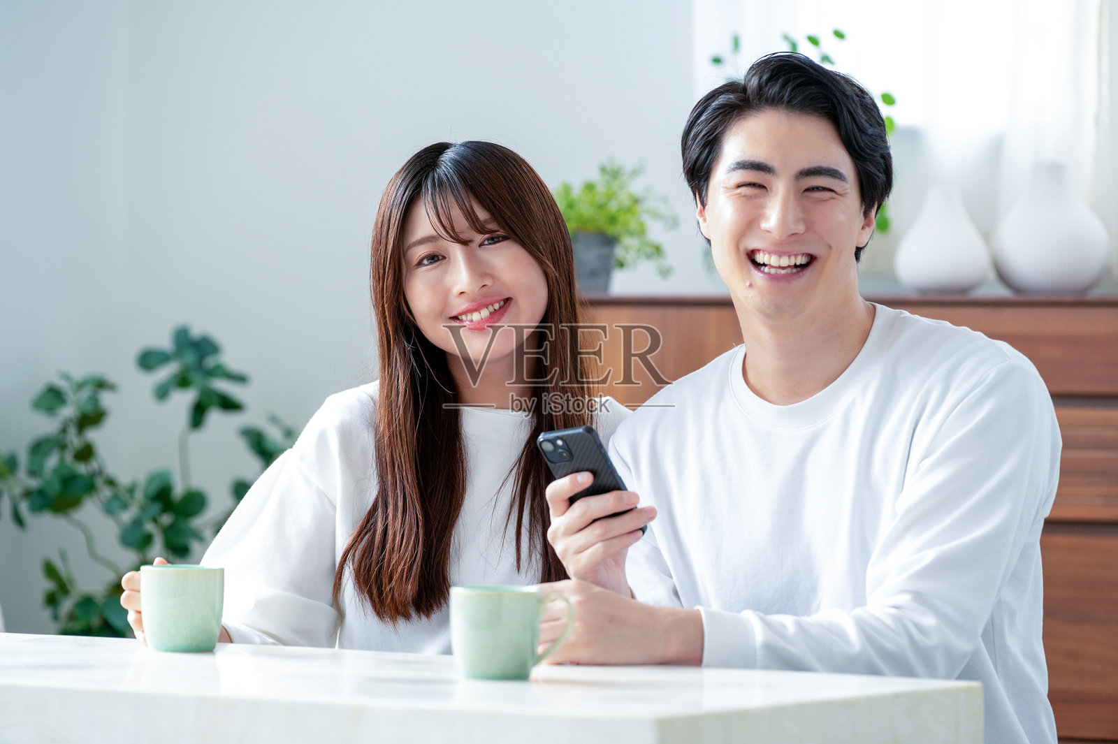 日本男女正在看智能手机照片摄影图片