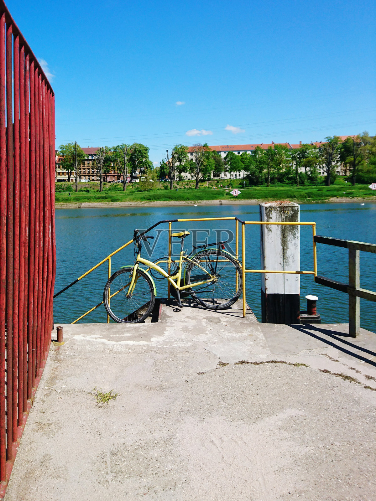 河边蓝天下停放在台阶上的自行车照片摄影图片