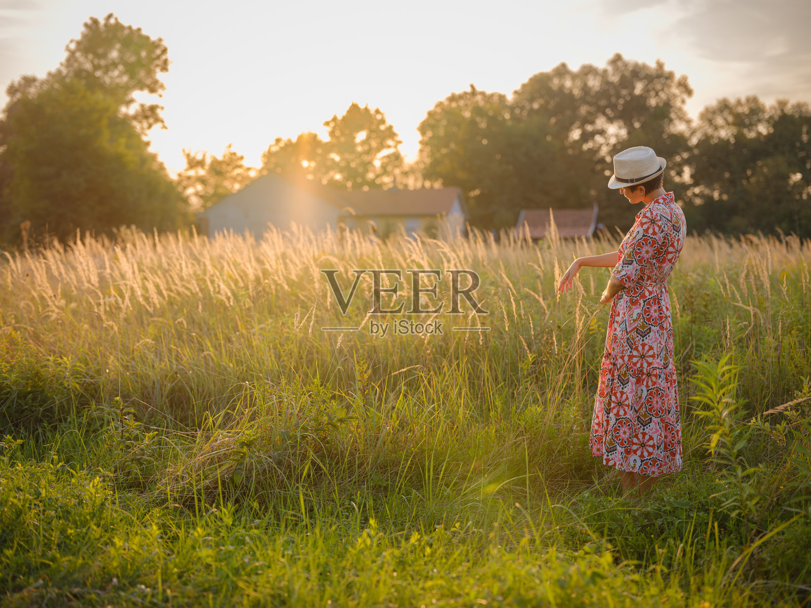 波西米亚风格的女性穿着花卉连衣裙,置身于欧洲乡村。照片摄影图片