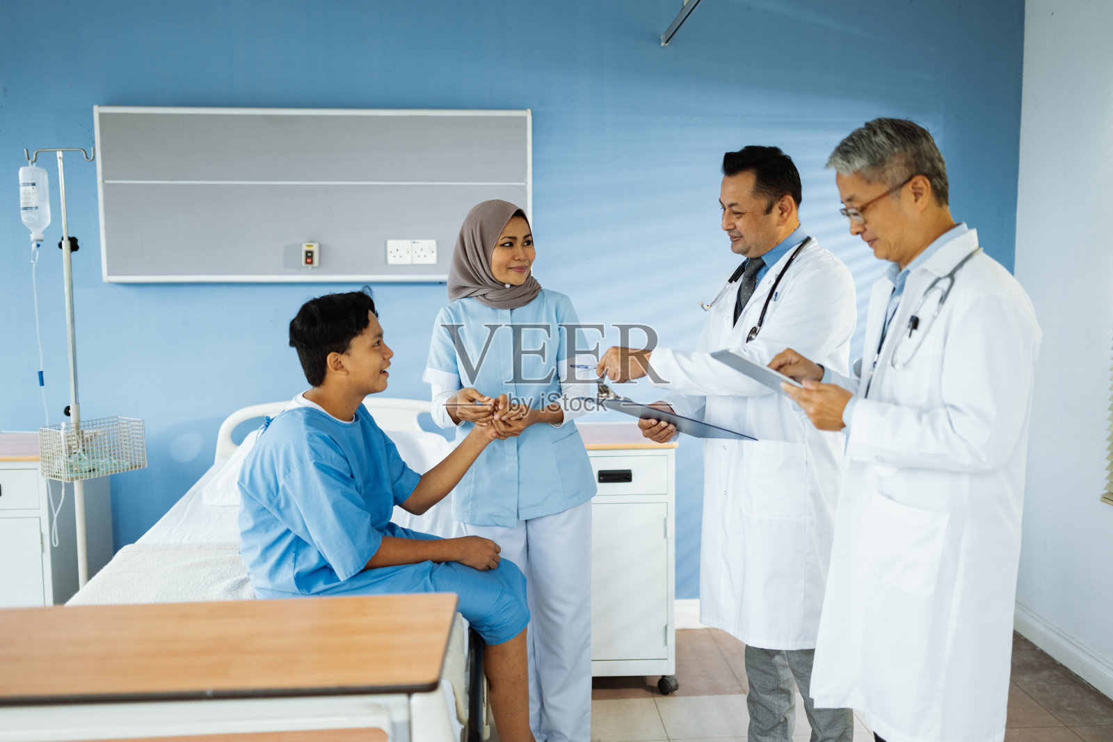 多元化的医生和护士在阑尾手术后检查年轻患者照片摄影图片