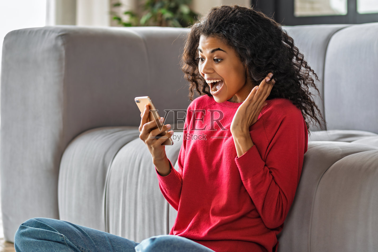 兴奋的女性手持手机庆祝照片摄影图片