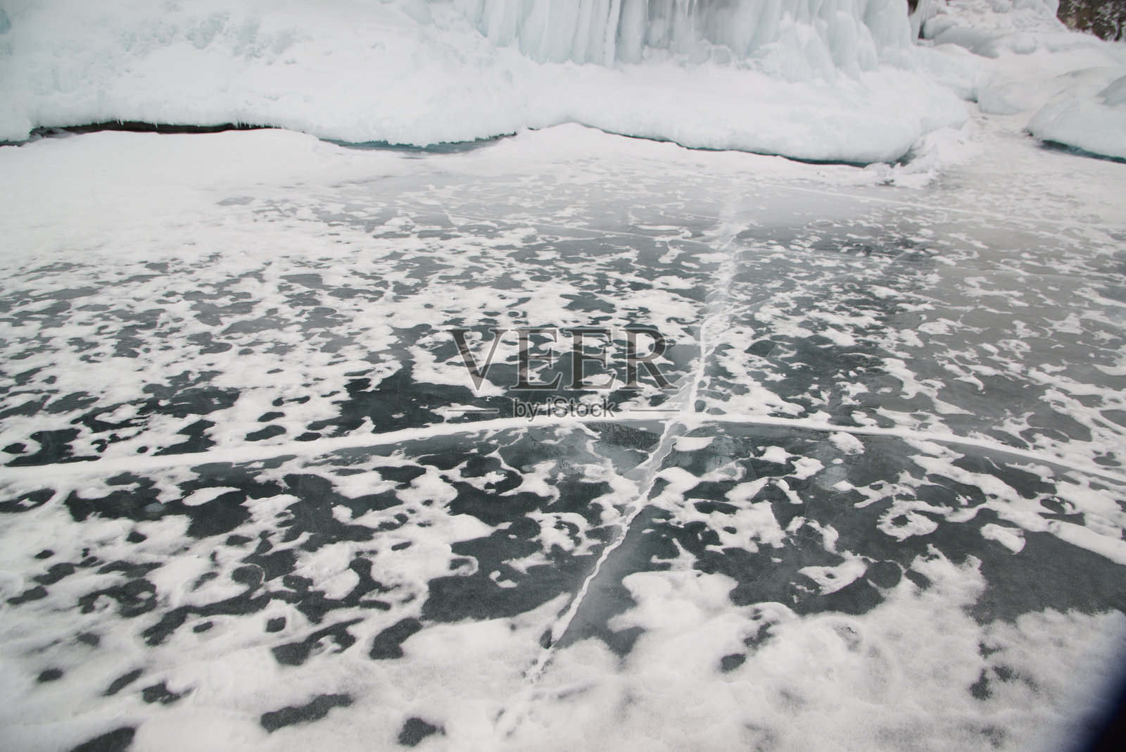 美丽的贝加尔湖冰面裂缝,冬季有霜冻的甲烷气泡。照片摄影图片